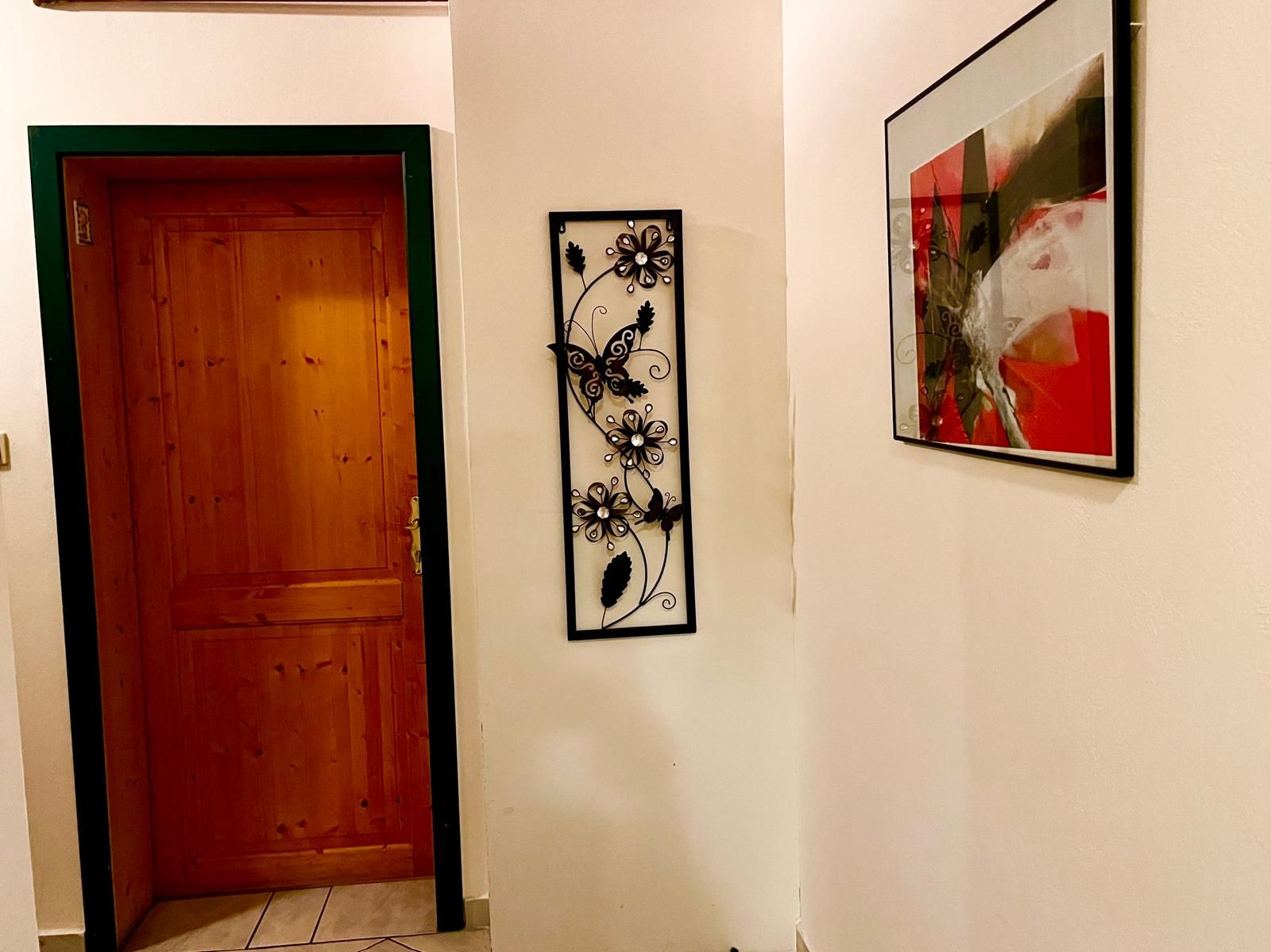 Hallway with wooden door, wall decoration and abstract picture.
