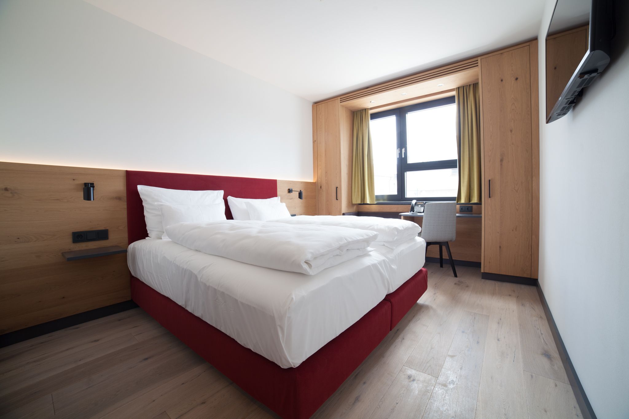 Double bed in bright room with window