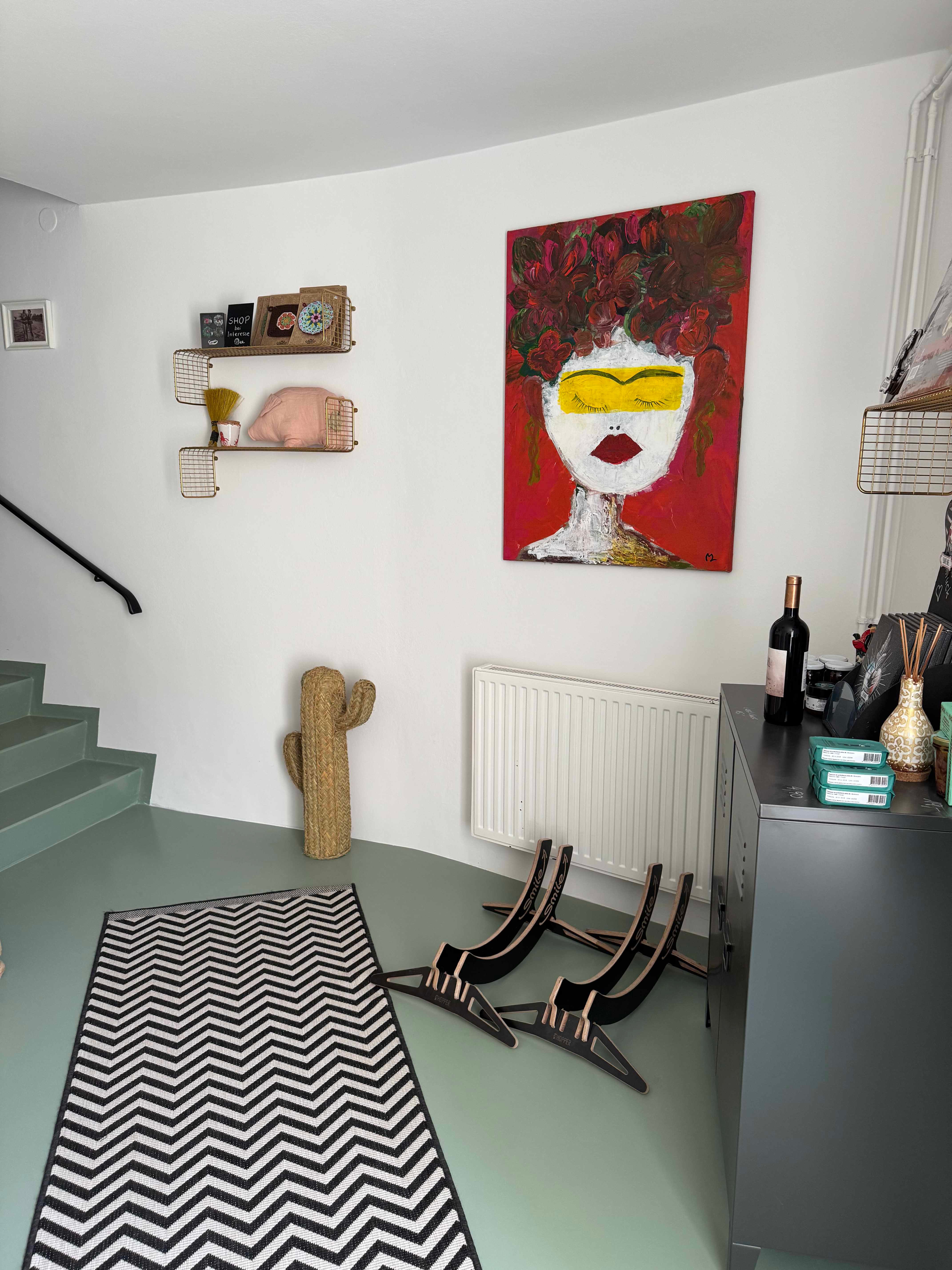 Entrance area with artwork, cactus decoration and striped carpet.