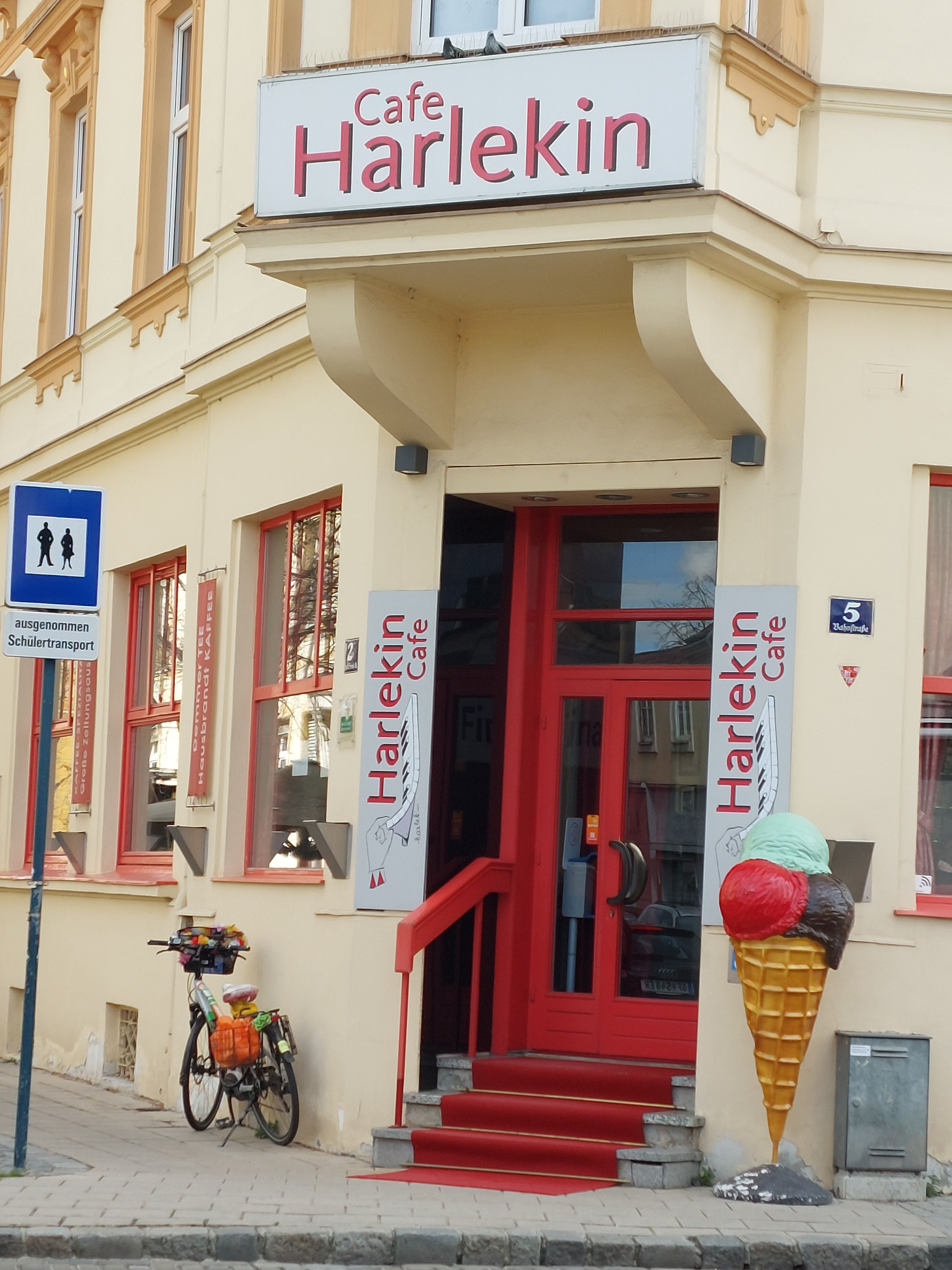 Entrance to Cafe Harlekin with red door and ice cream cone decoration.