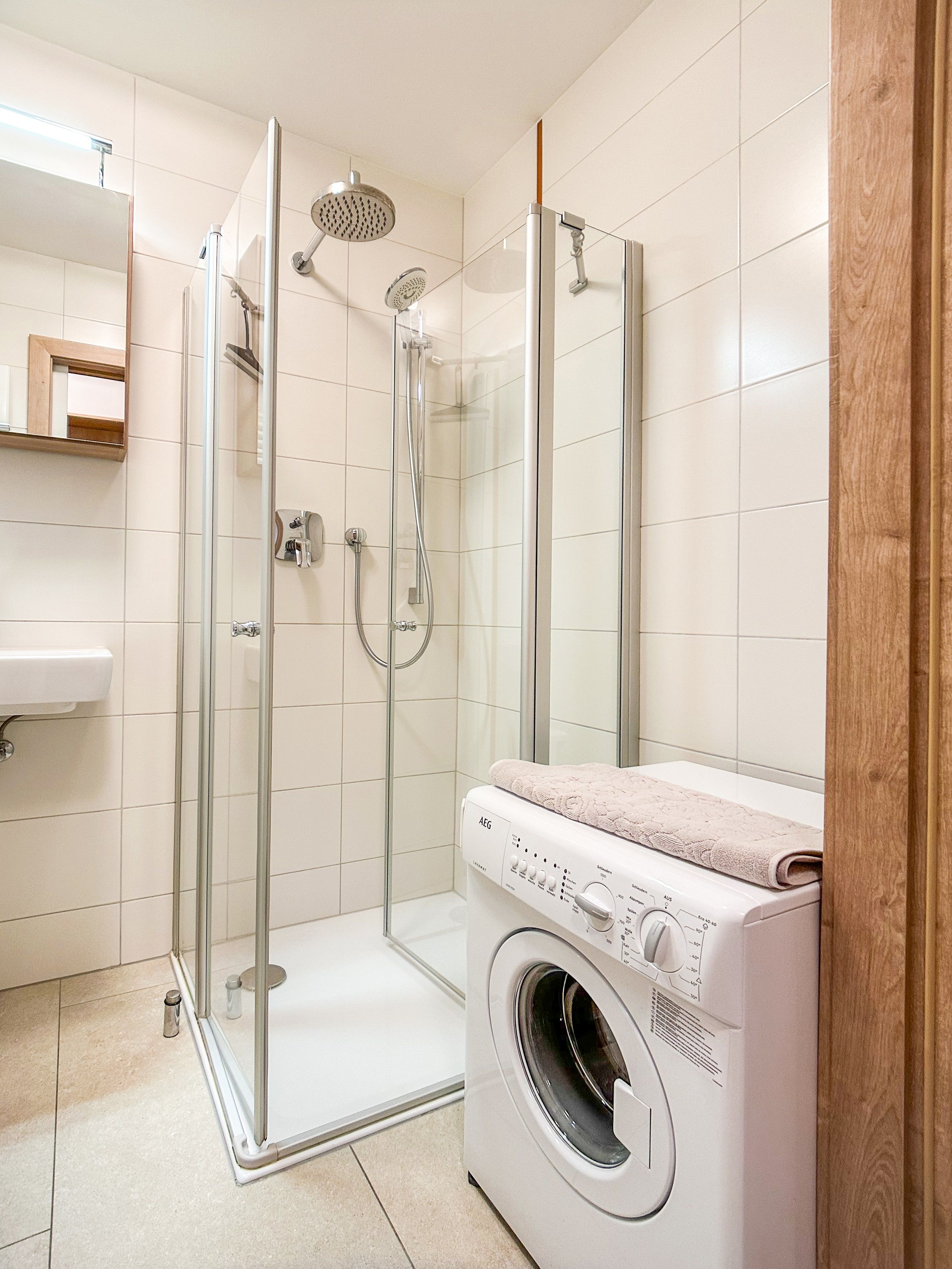 Modern bathroom with shower and washing machine.