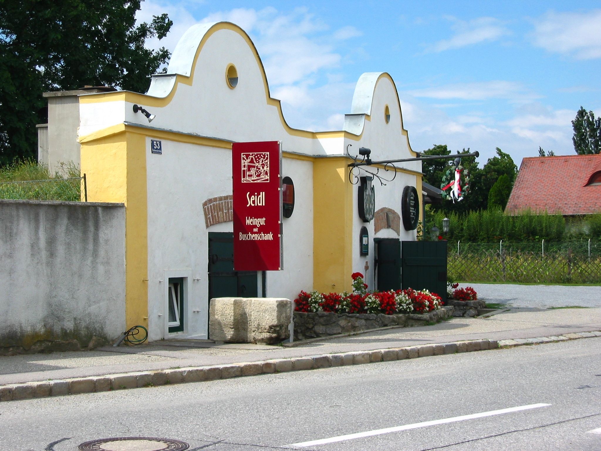 Seidl winery with yellow building and red sign.