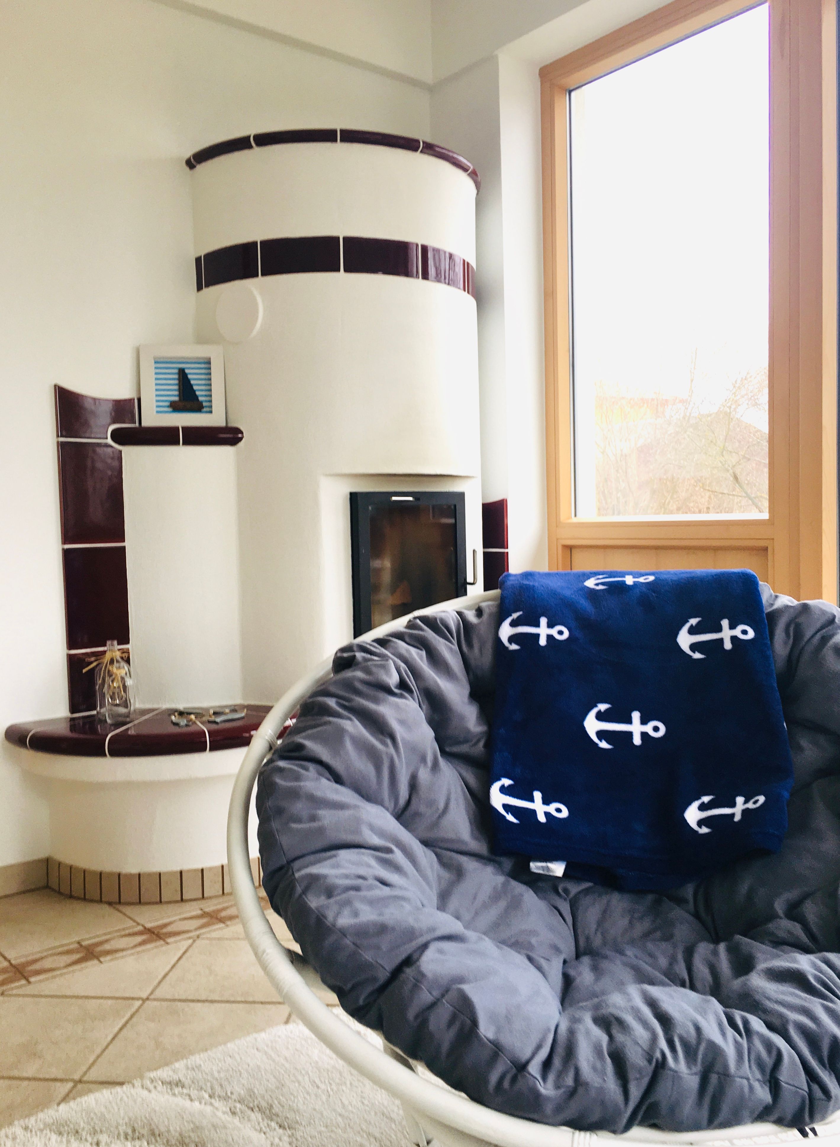Cozy living room with tiled stove and armchair.