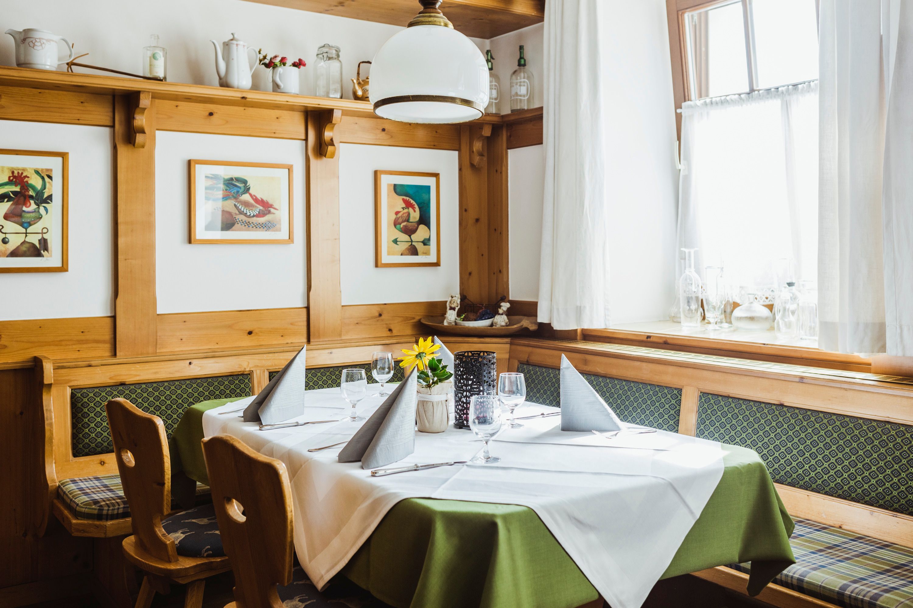Cozy living room with wooden furniture, table setting and pictures on the wall.