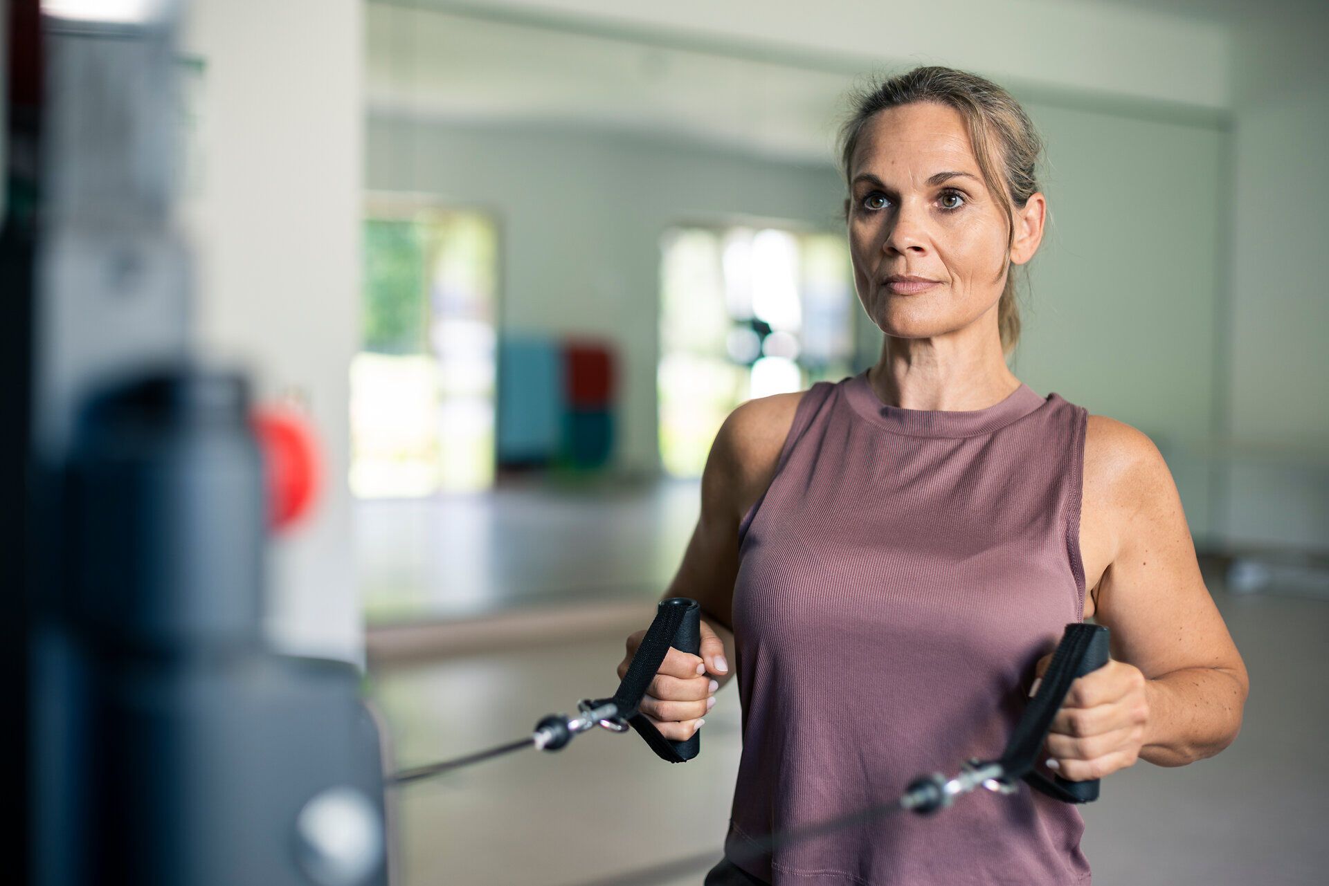 A woman is working out on a cable machine at the Moorbad Bad Großpertholz in the Waldviertel region.