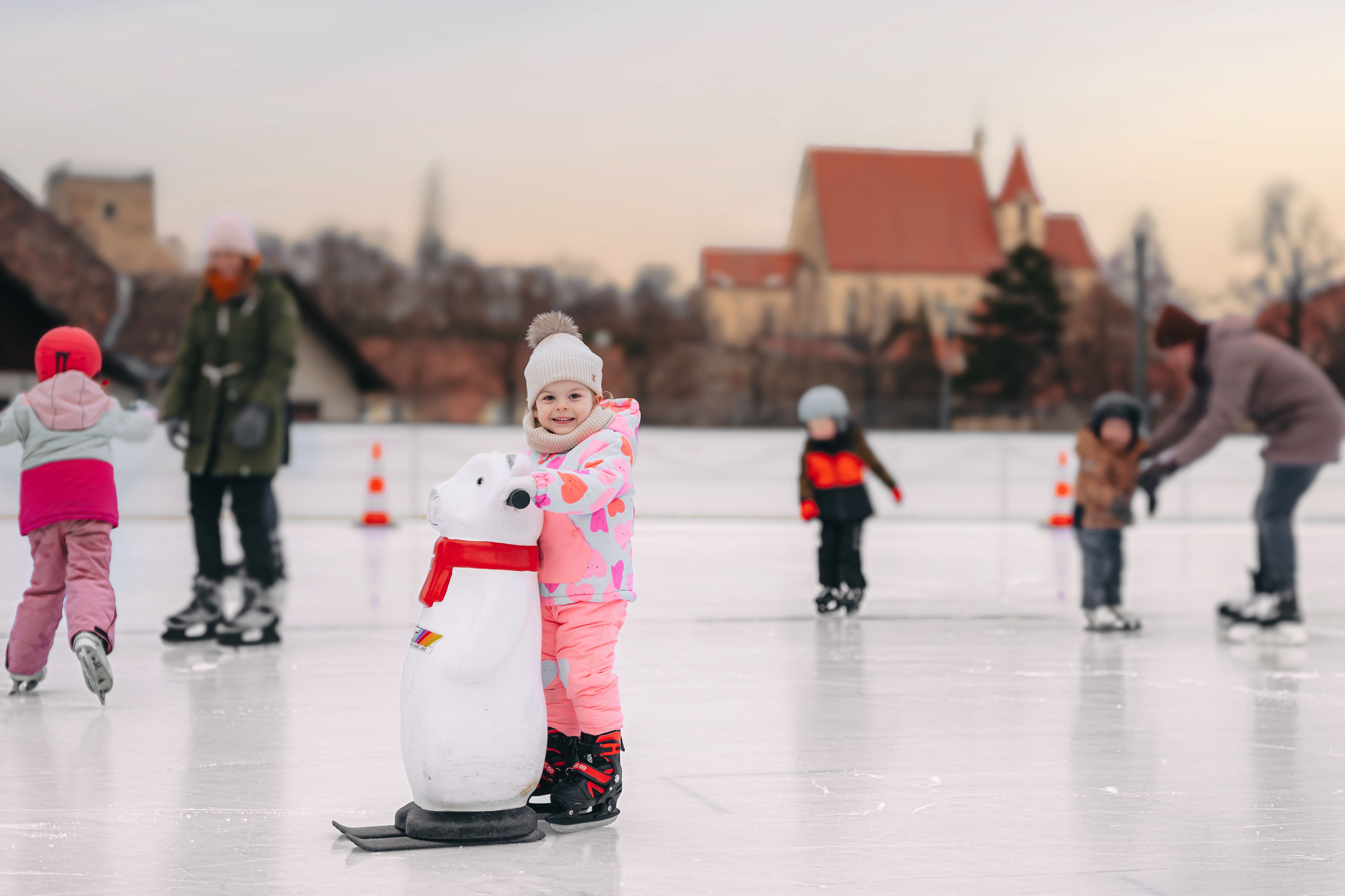 Children skating on a square with a church in the background.