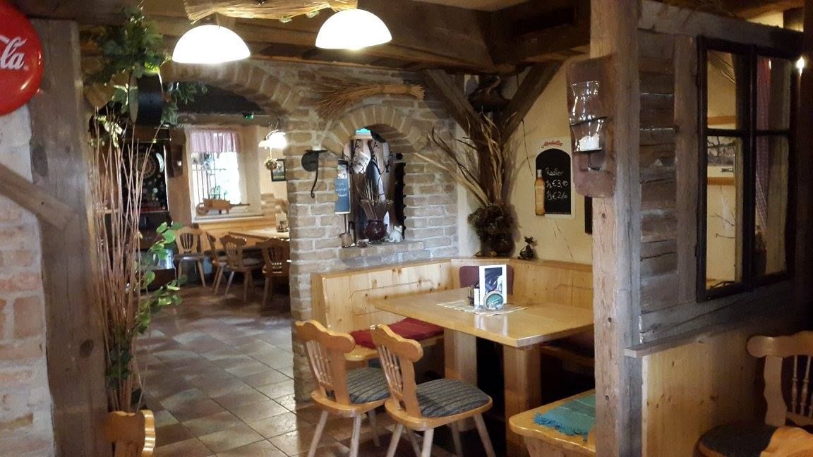 Cozy interior of a rustic pub with wooden furniture and brick walls.
