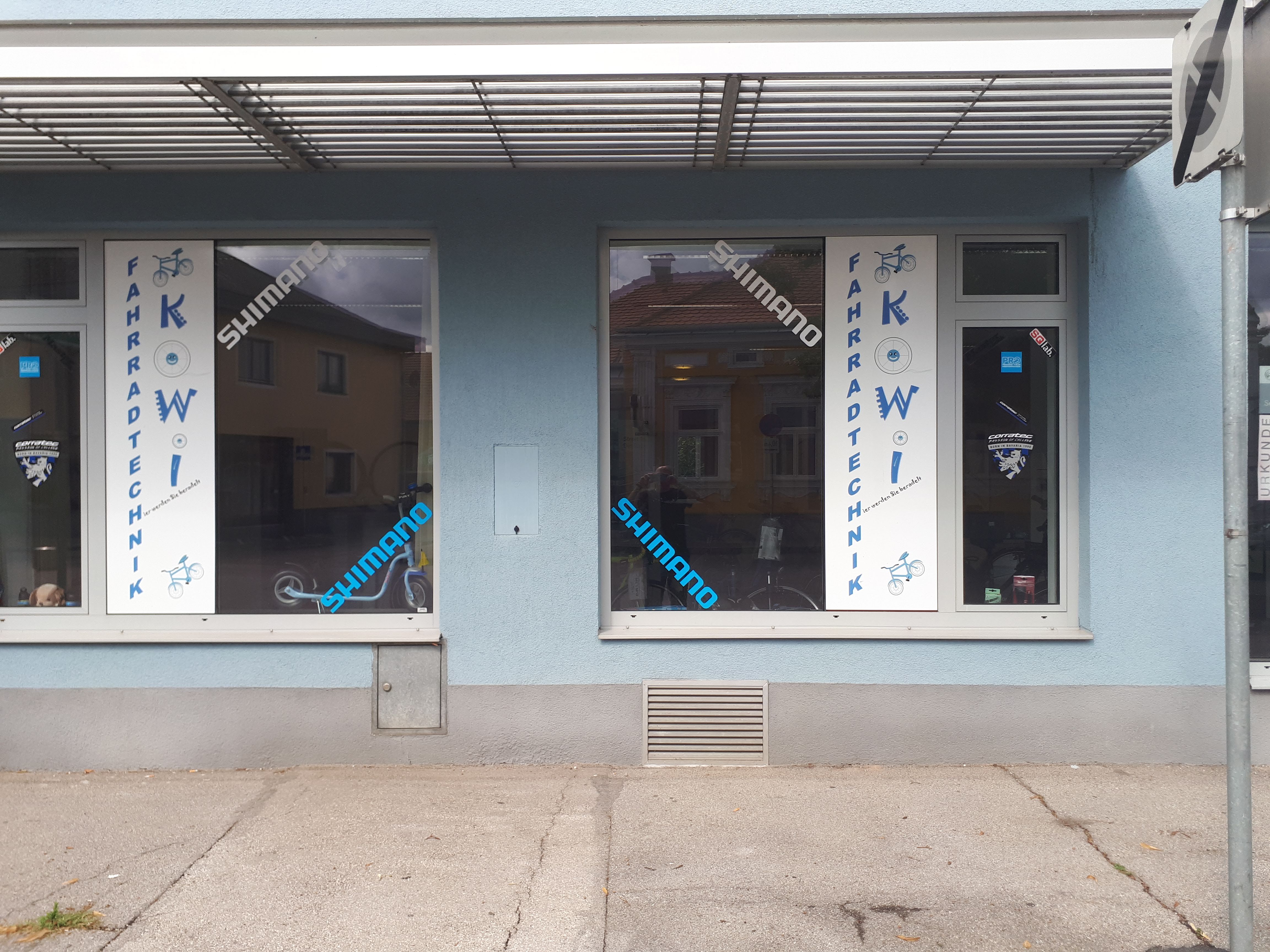 Bicycle store with blue facade and shop windows with the inscription 'Fahrradtechnik KOWI'.
