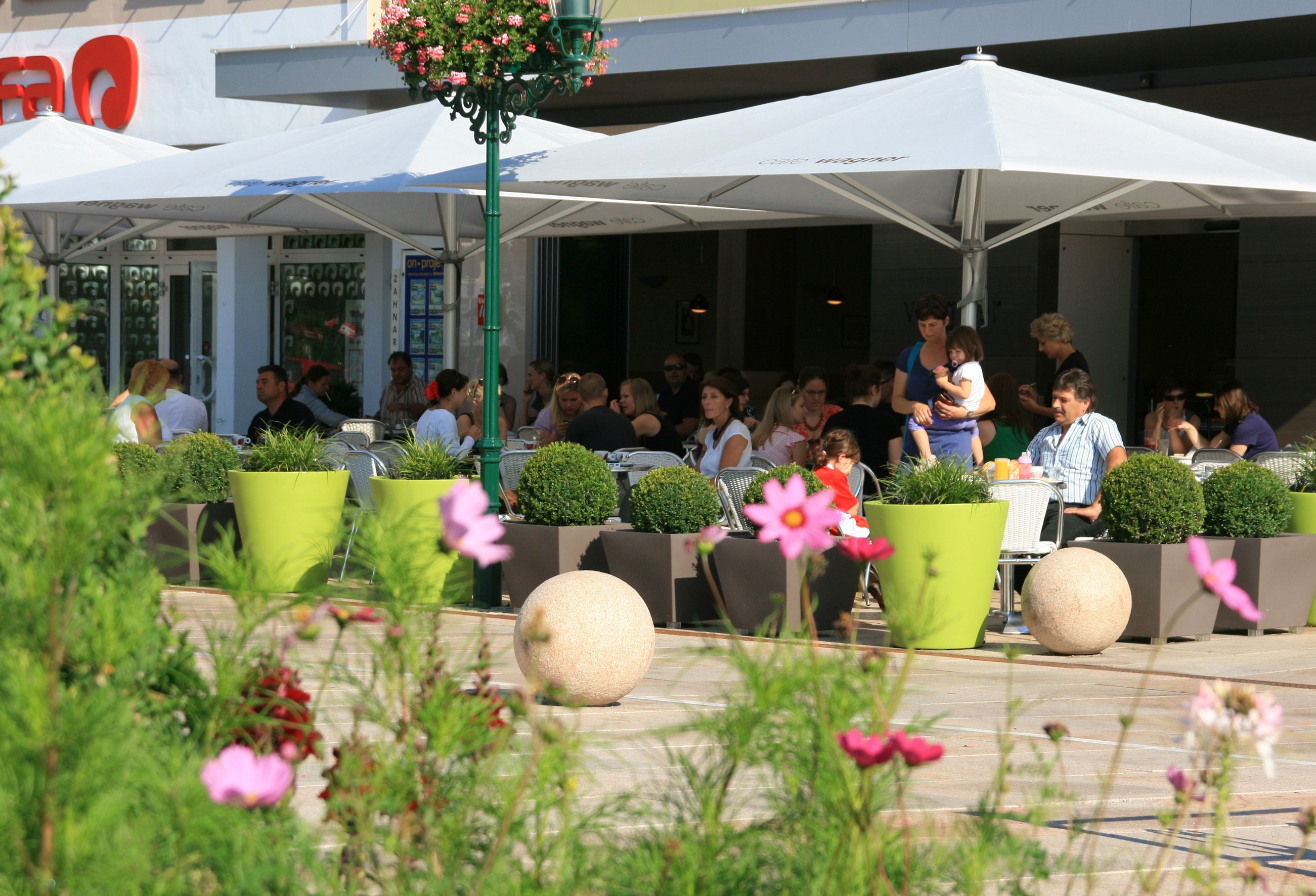 Outdoor area of a café with people under parasols.