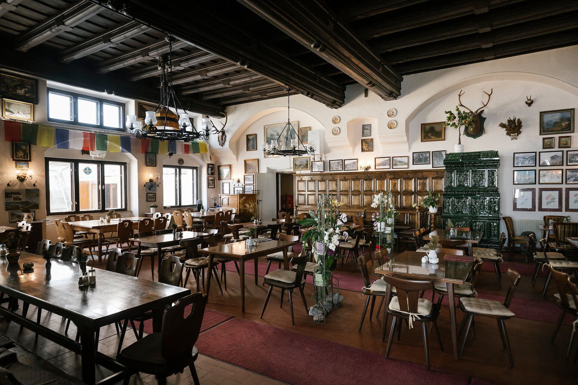 Historic dining room with a tiled stove and wooden ceiling at the Berghaus Hochschneeberg