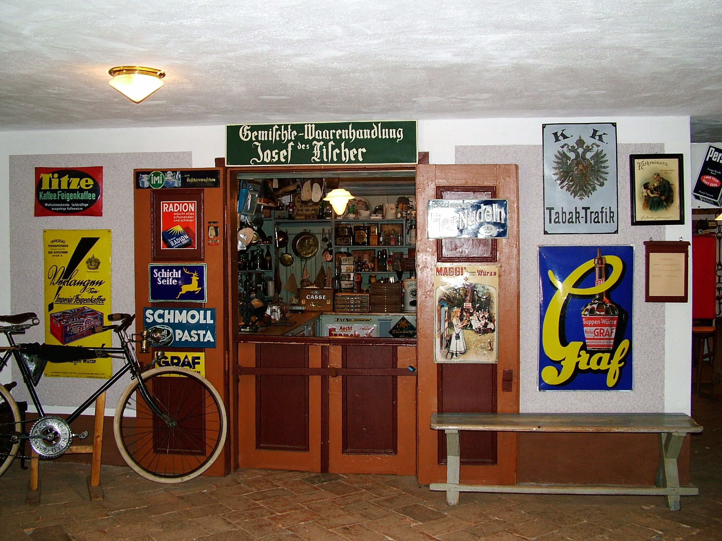 Historic store in the Mostviertel Farmers' Museum with old advertising signs and a bicycle.