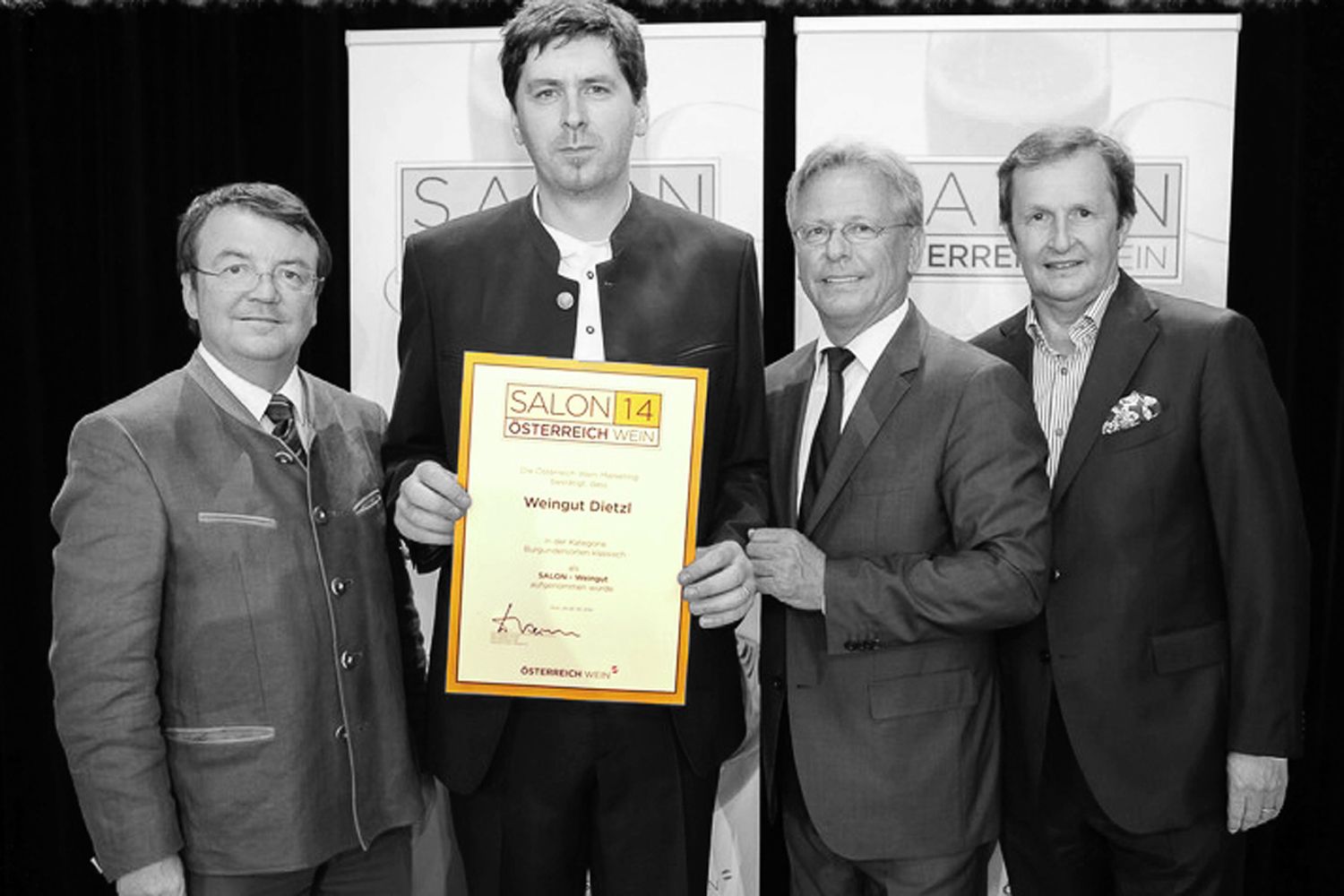 Four men in suits hold an award with the inscription 'Salon 14 Austria Wine' up to the camera.