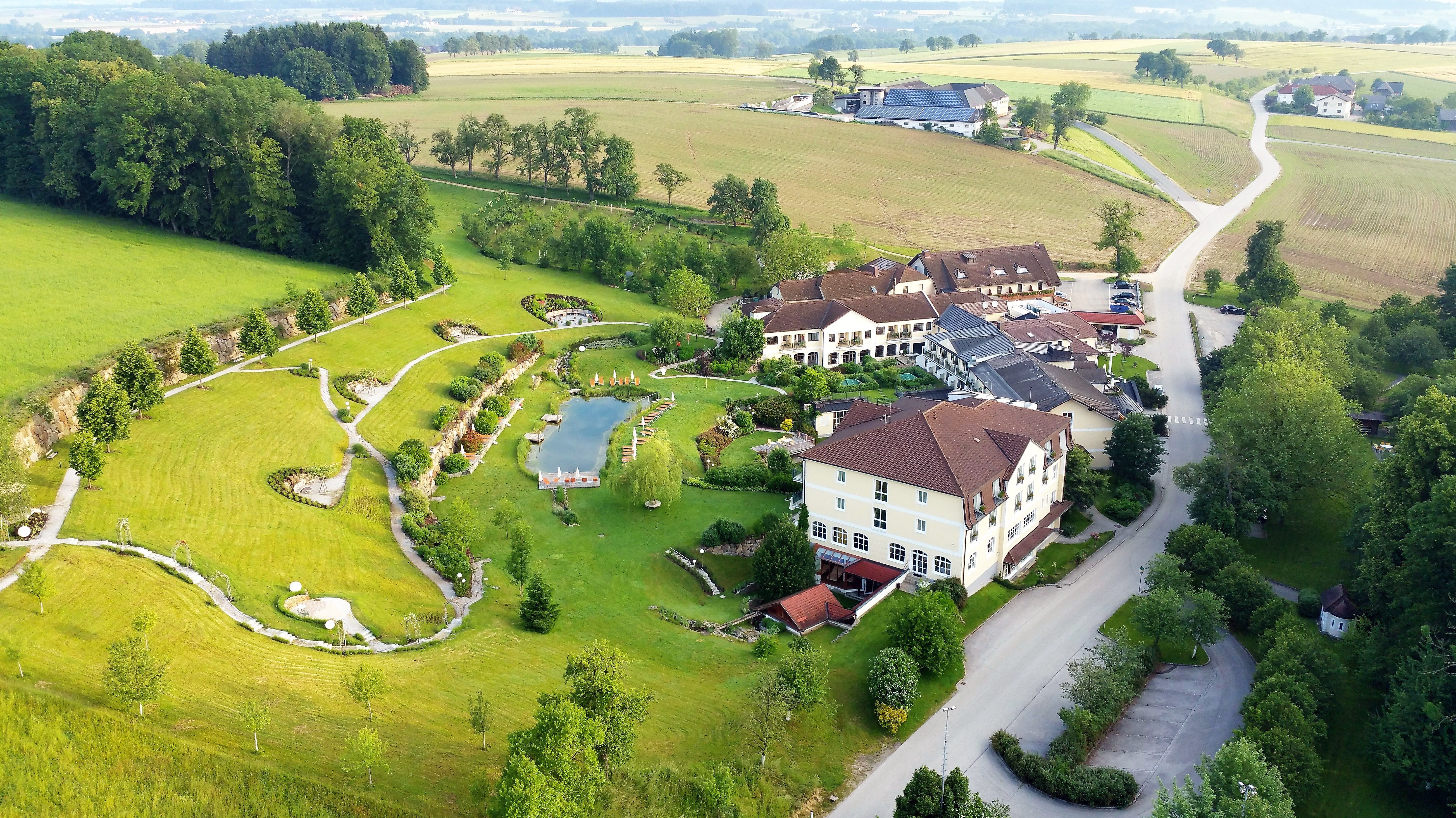 Aerial view of a resort with garden and pond in a rural setting.
