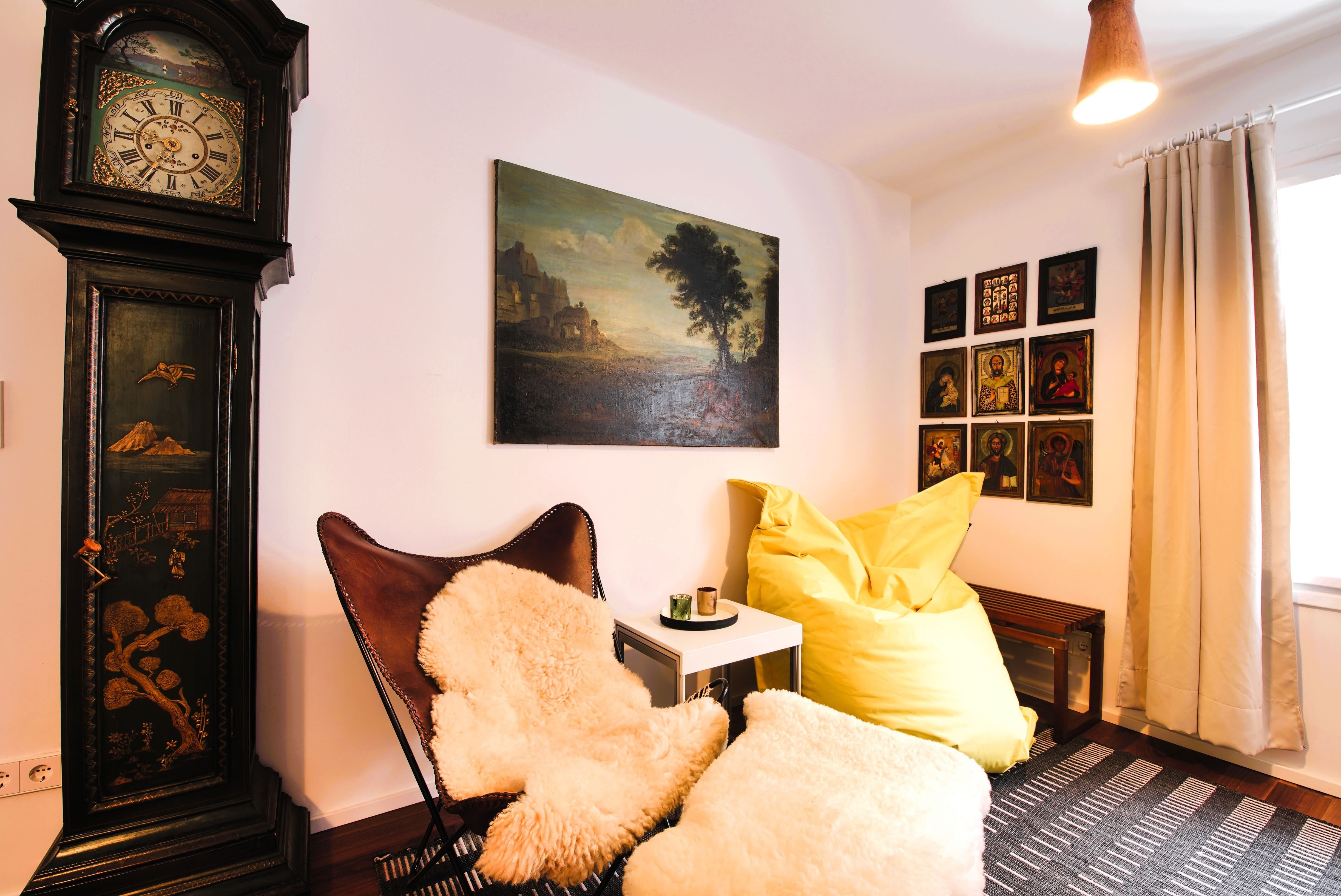 Cozy seating area with leather armchair, yellow beanbag, antique grandfather clock and murals.