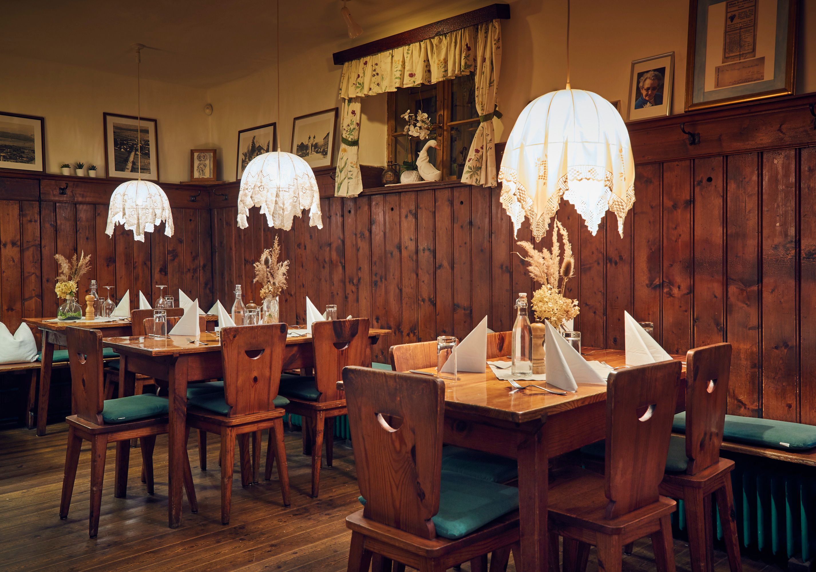Cozy living room with wooden furniture, table decorations and hanging lamps.