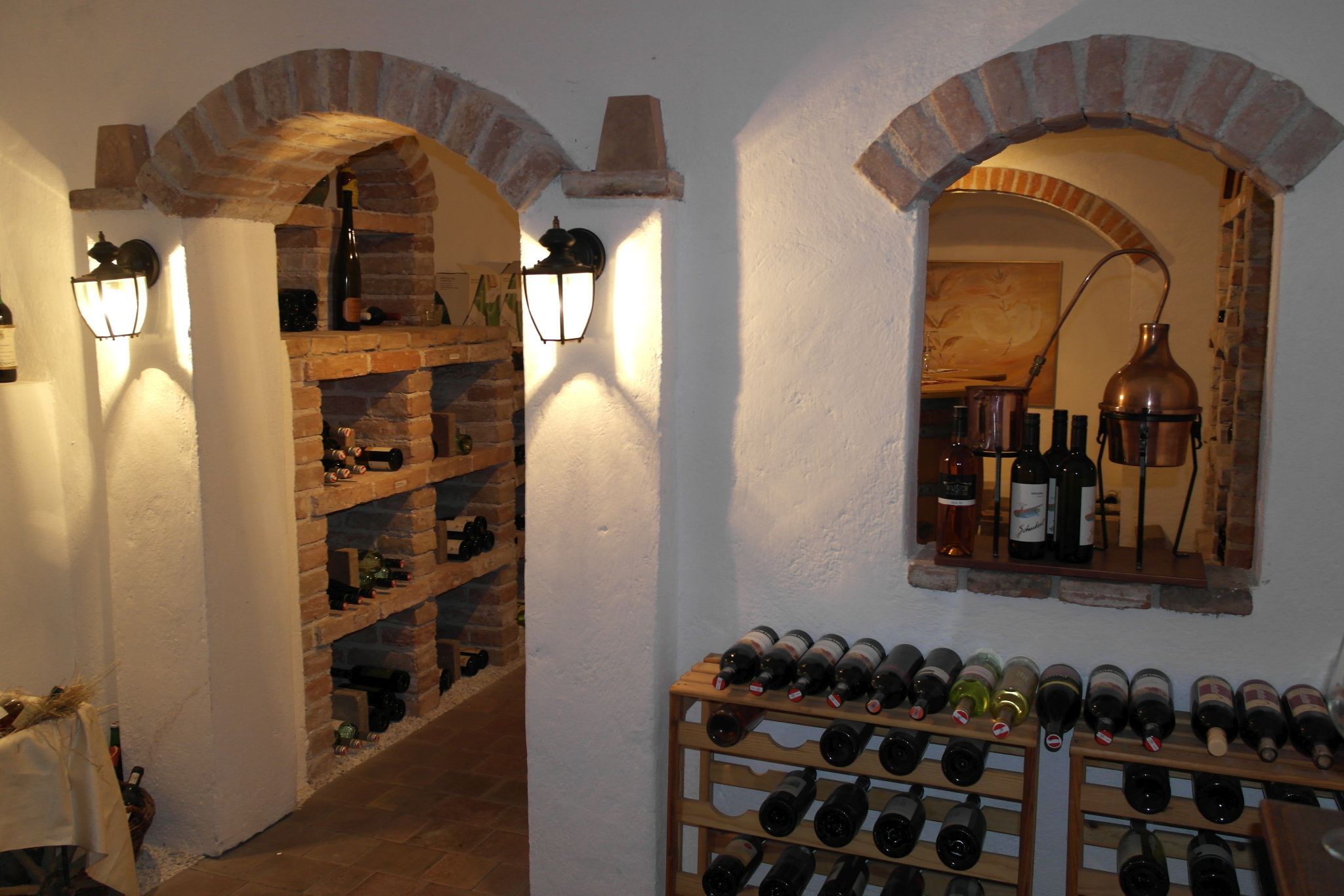 A wine cellar with bottle racks and brick arches.