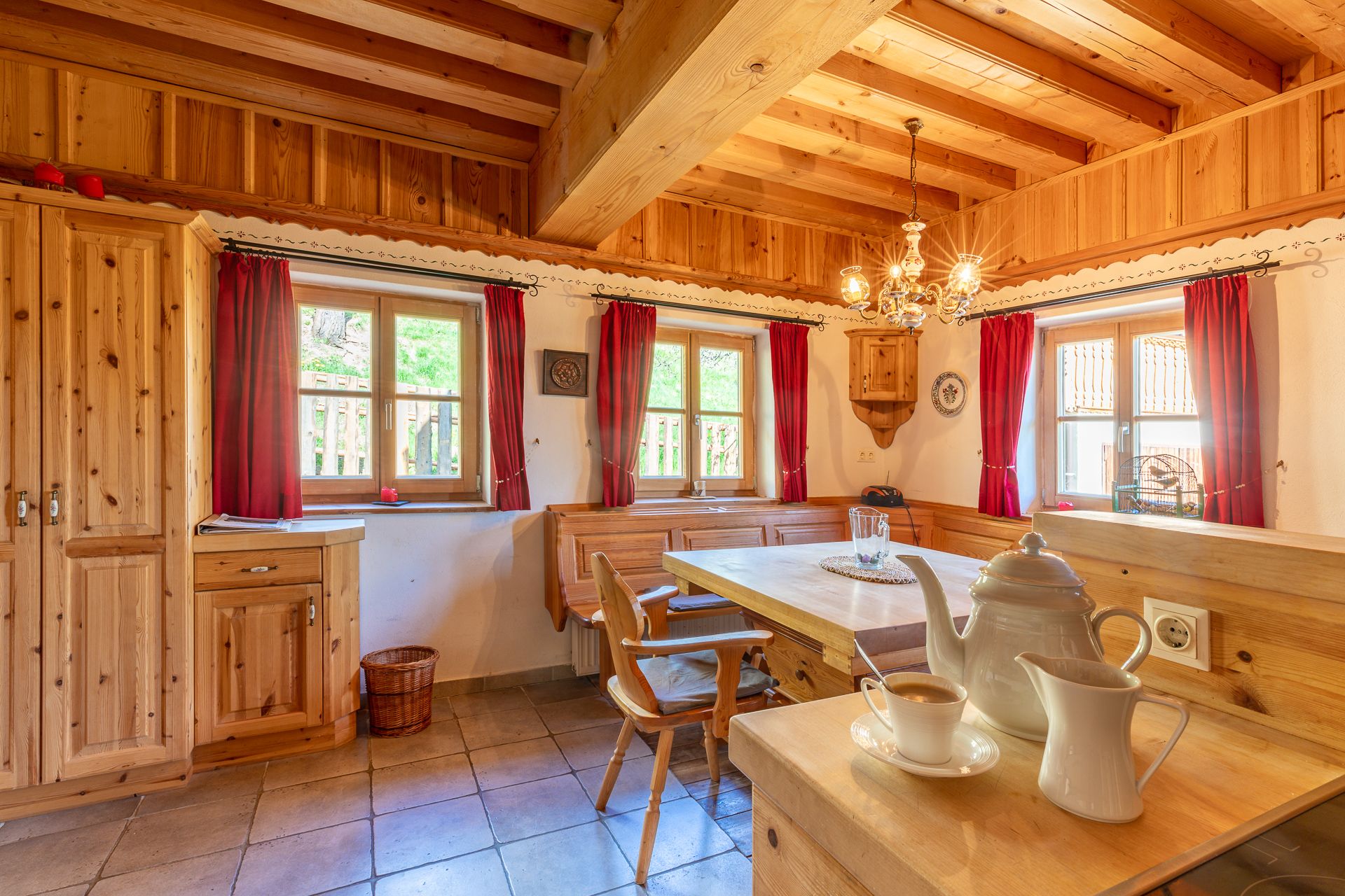 Traditional-style dining area with wooden furniture and red curtains.