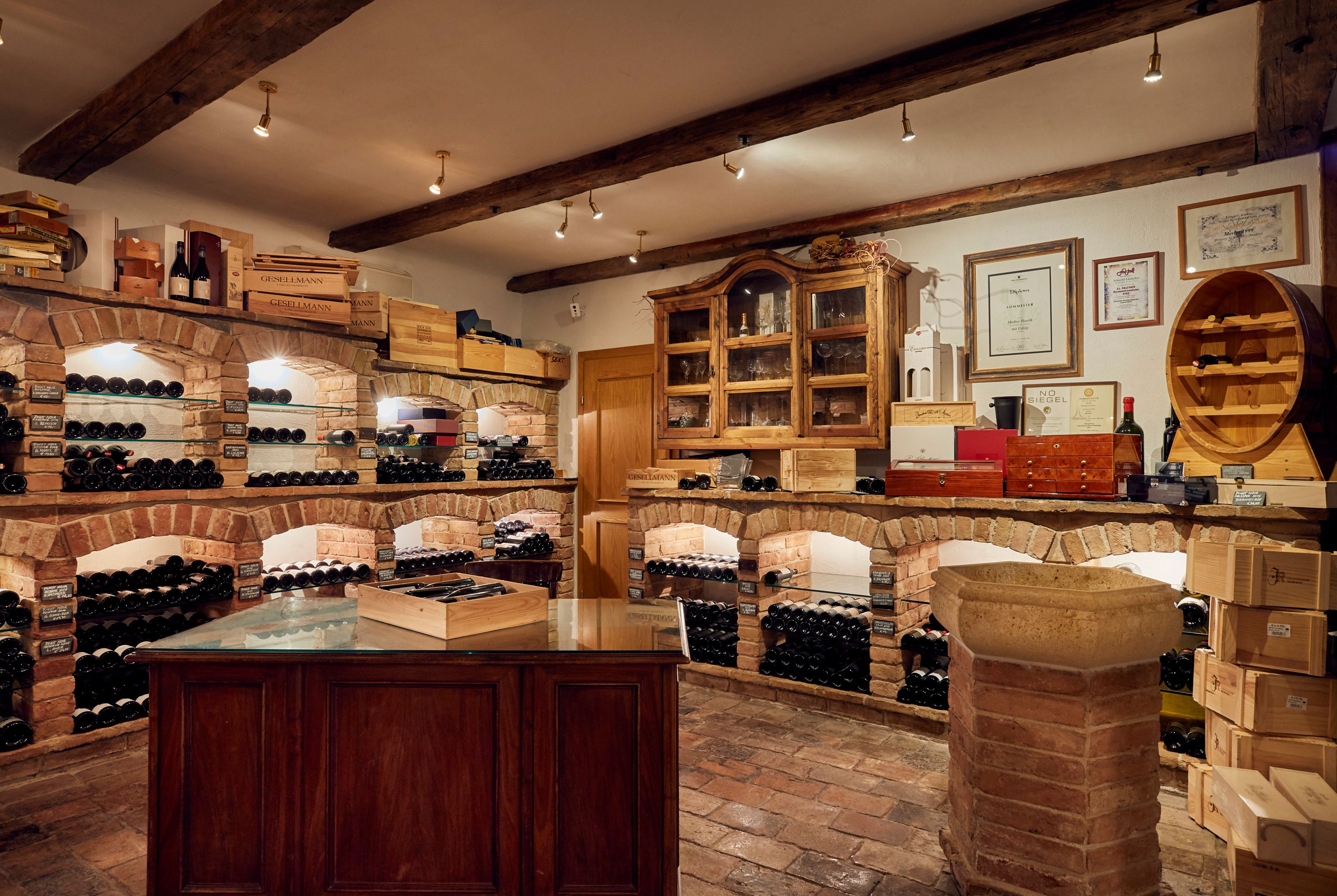 Wine cellar with brick shelves and wine bottles.
