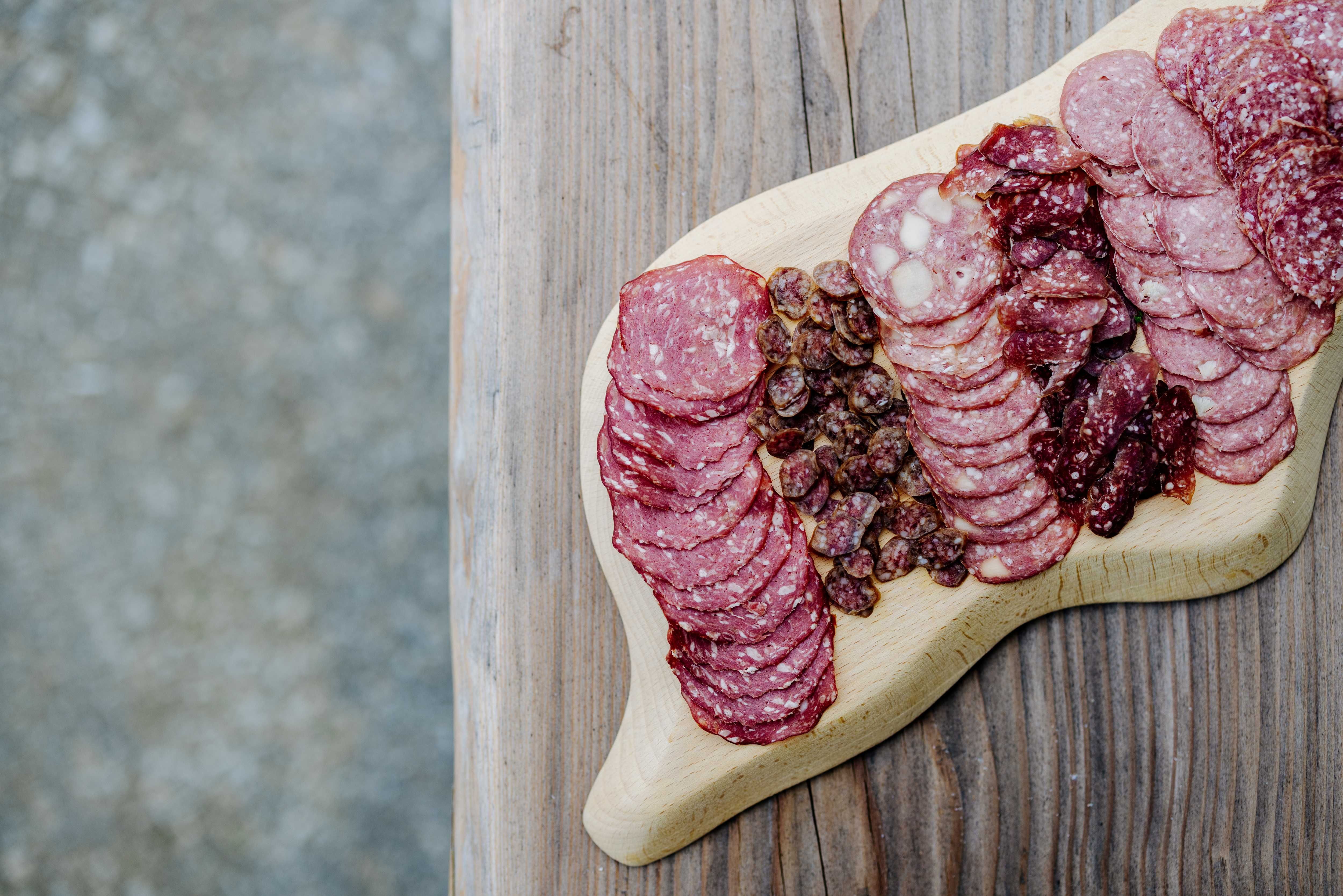 Different types of sausage on a wooden board.