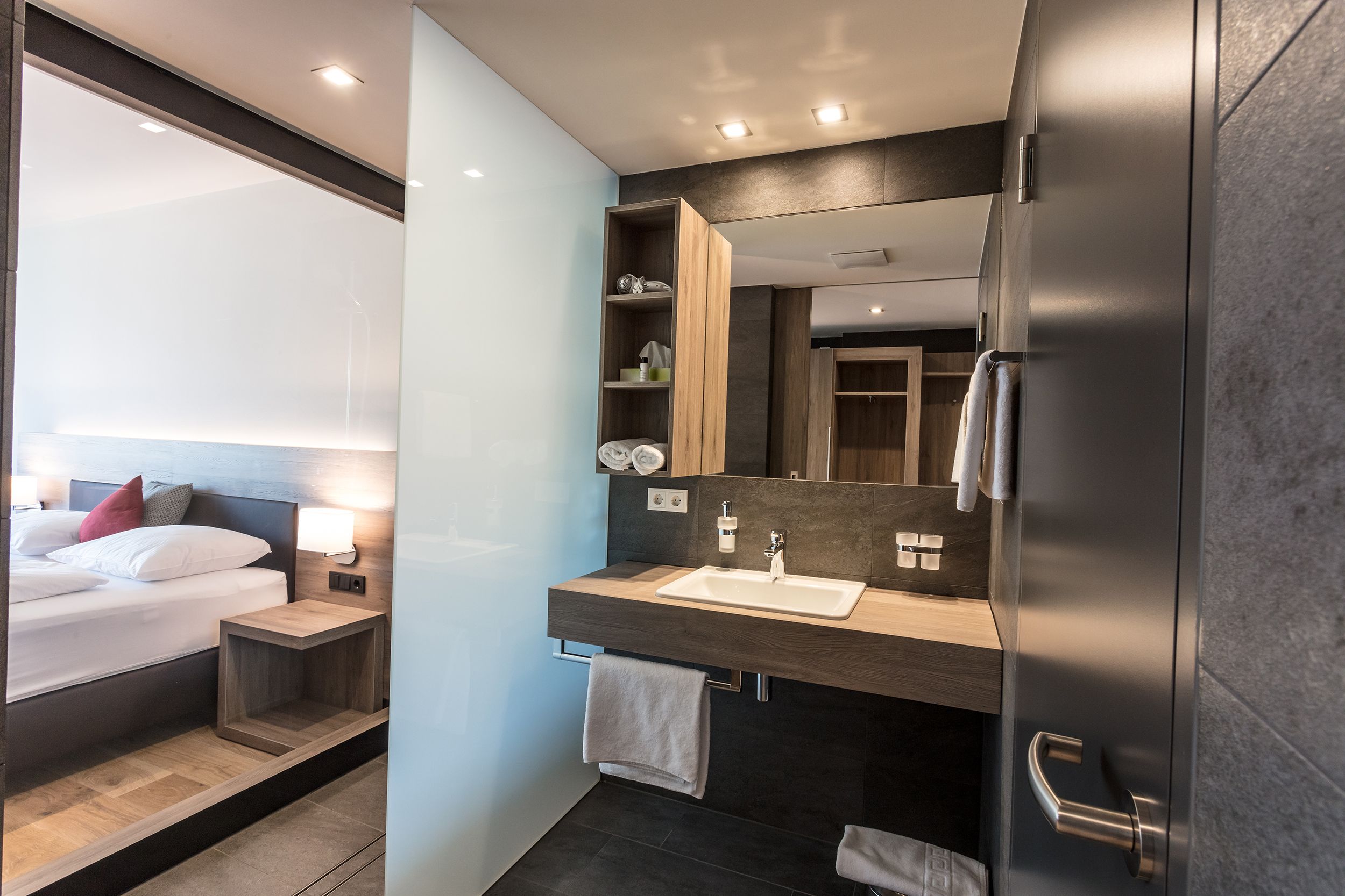 Modern hotel room with bathroom and double bed.