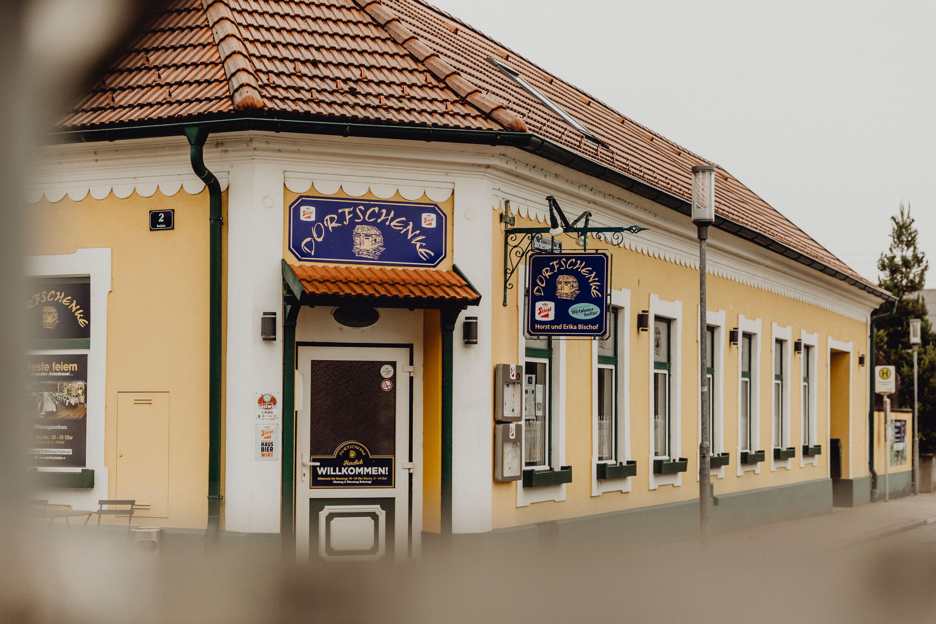 Yellow inn with 'Dorfschenke' sign, traditional ambience.