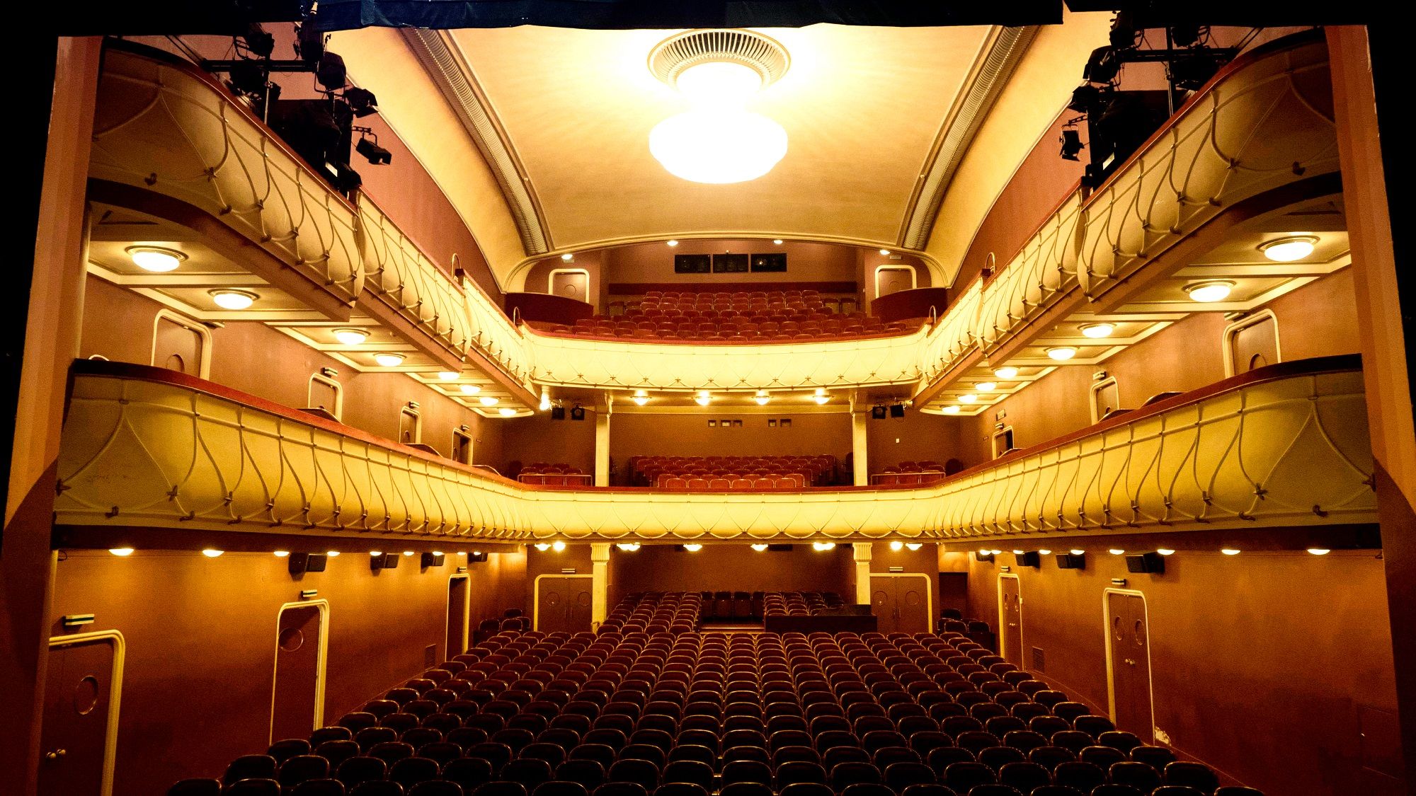 Interior view of the Wiener Neustadt City Theater with empty rows of seats and balconies.
