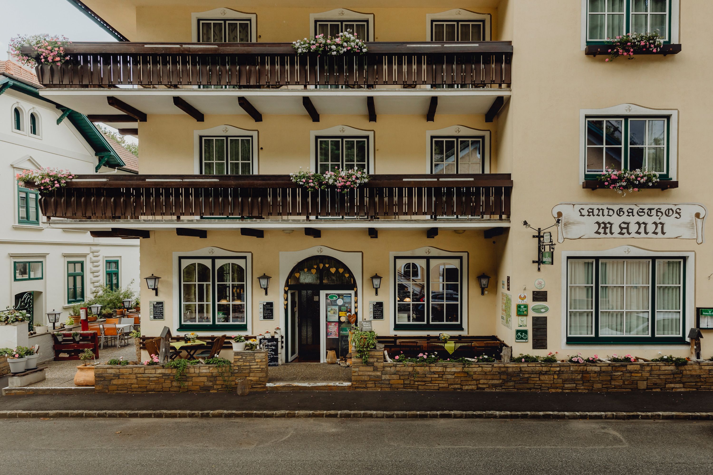 Facade of a traditional inn with balconies and flower boxes.