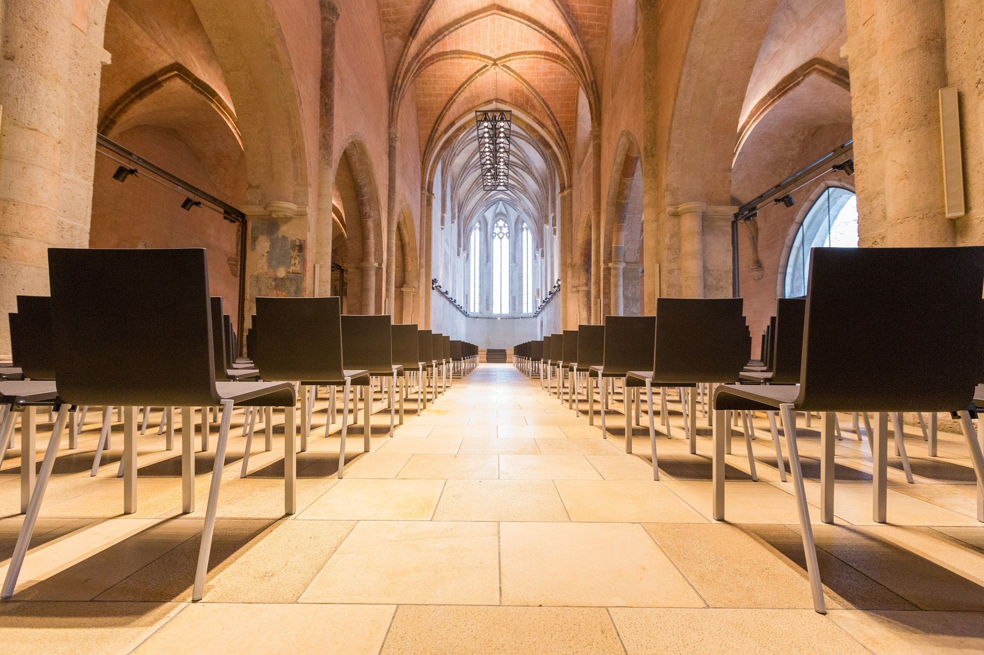 Interior view of a Gothic hall with rows of chairs.