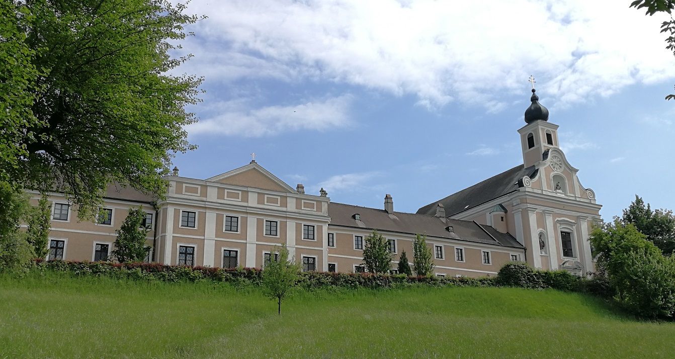 Maria Jeutendorf pilgrimage church with blue sky and green meadow.