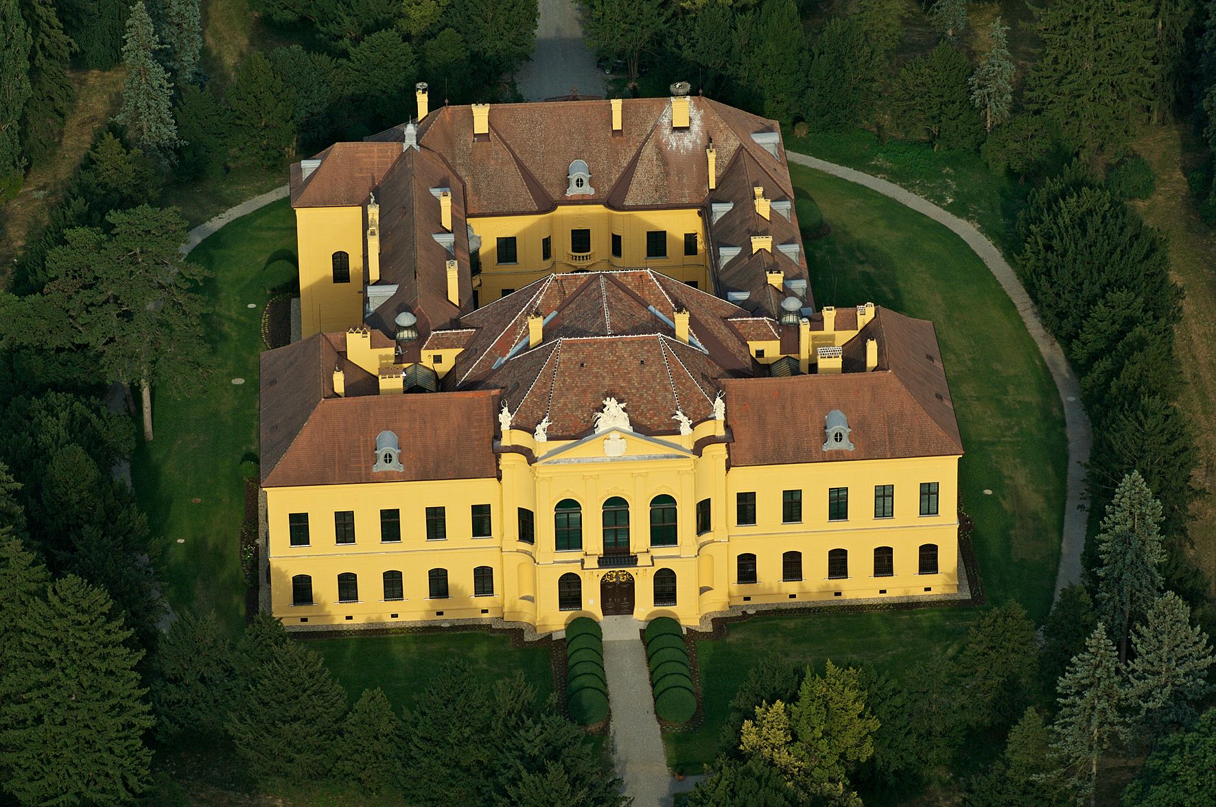 Aerial view of Eckartsau Castle, surrounded by trees and gardens.