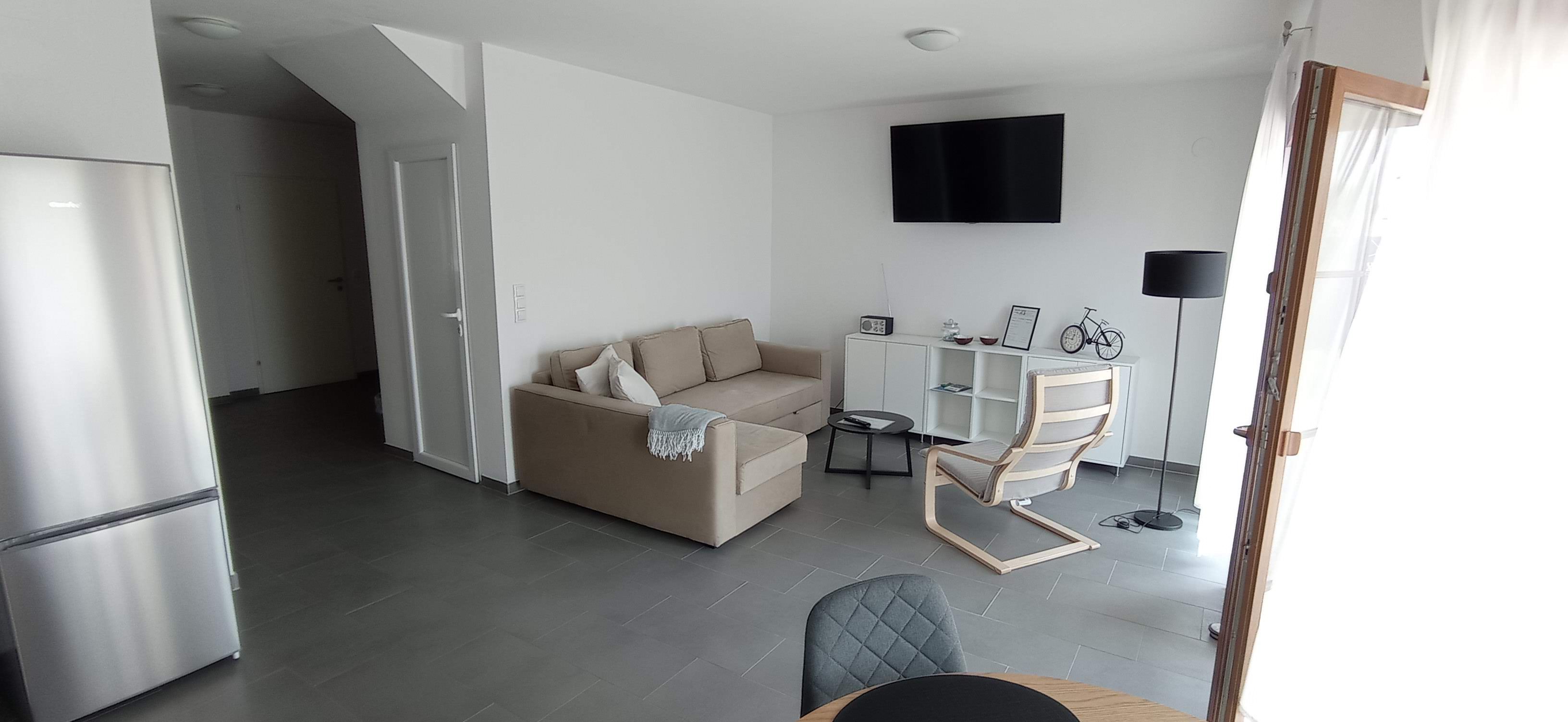 Living room with beige couch and white walls 