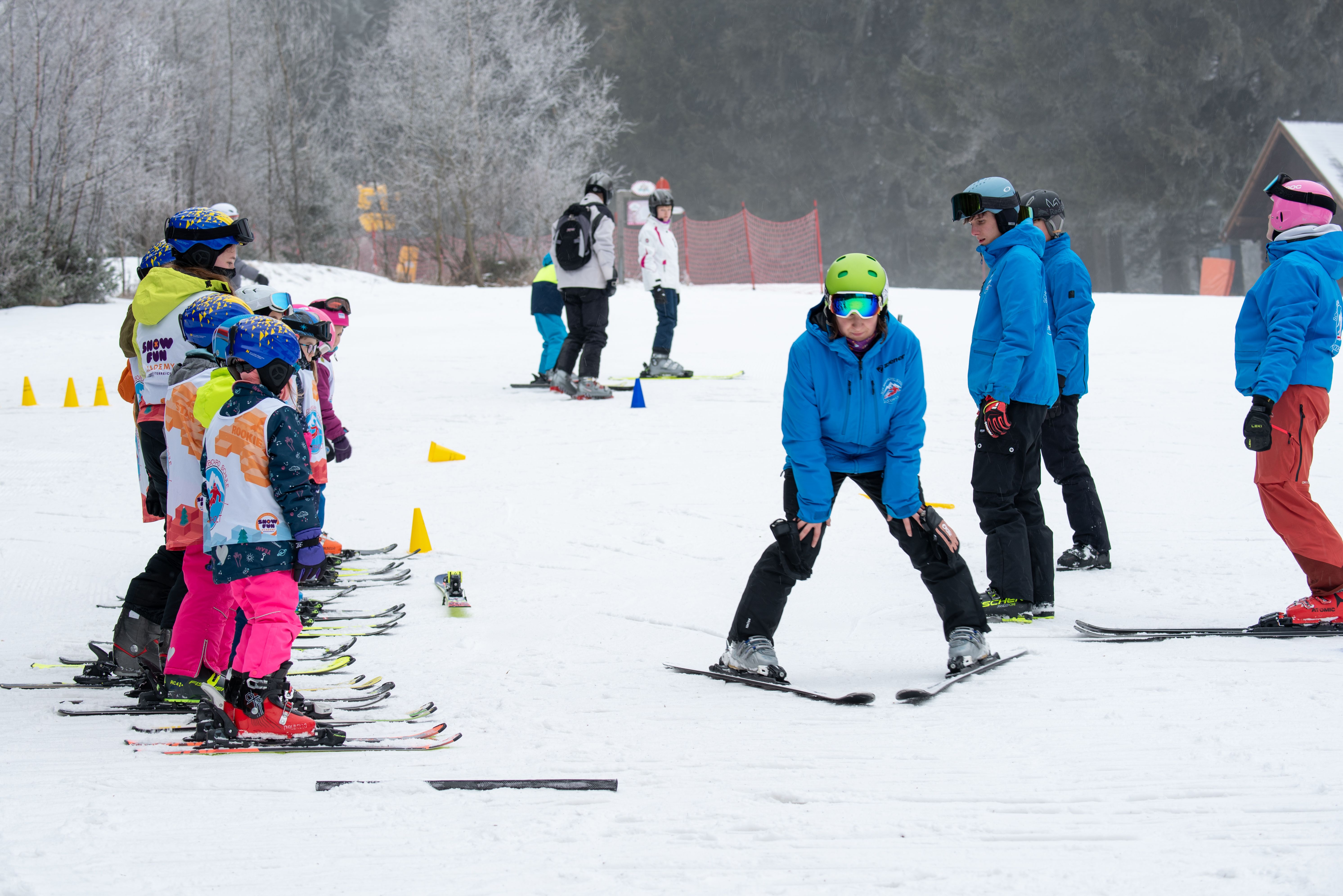 Ski instructor shows children on skis an exercise on a ski slope.