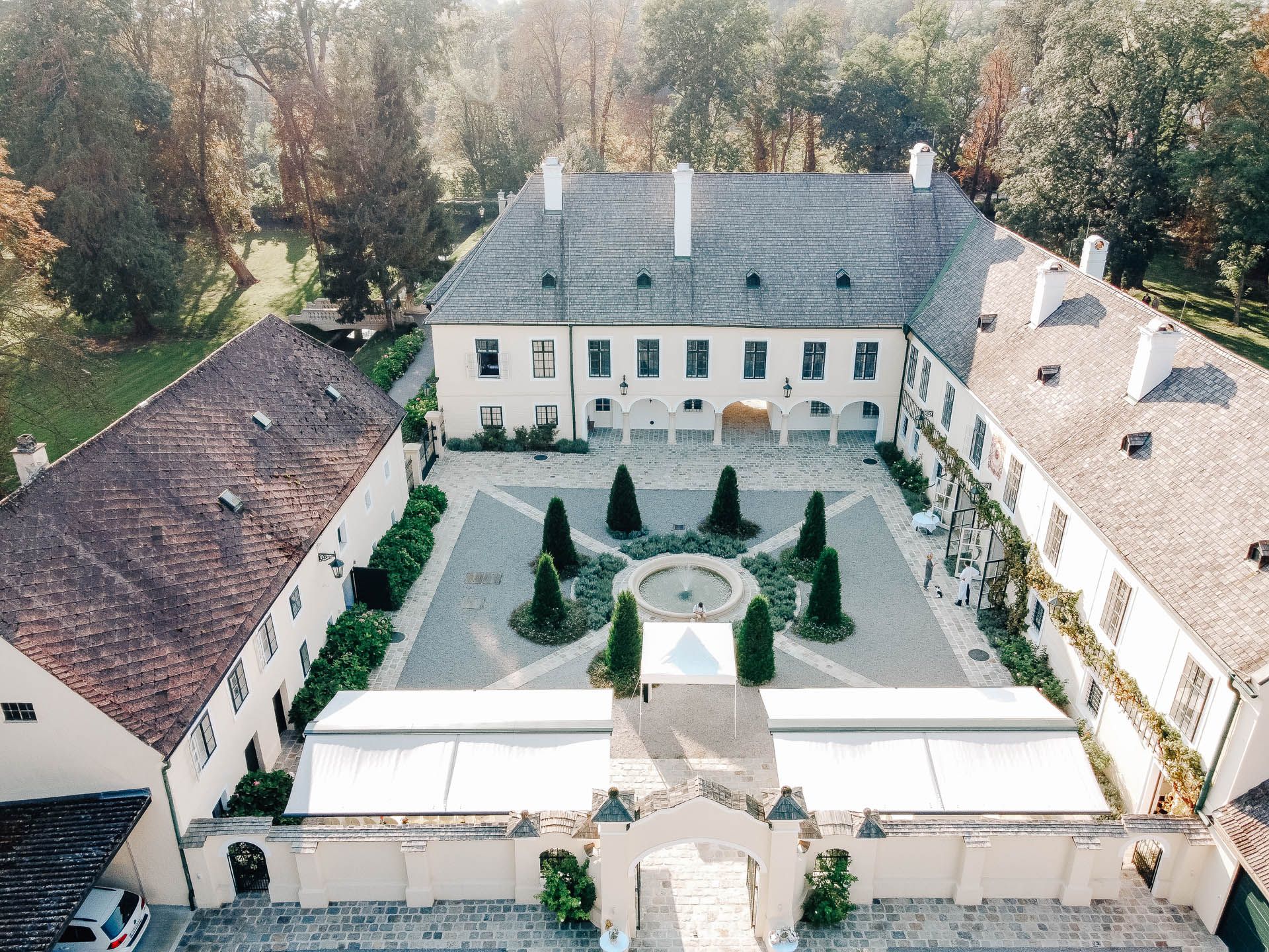 Aerial view of a historic castle with courtyard and garden.