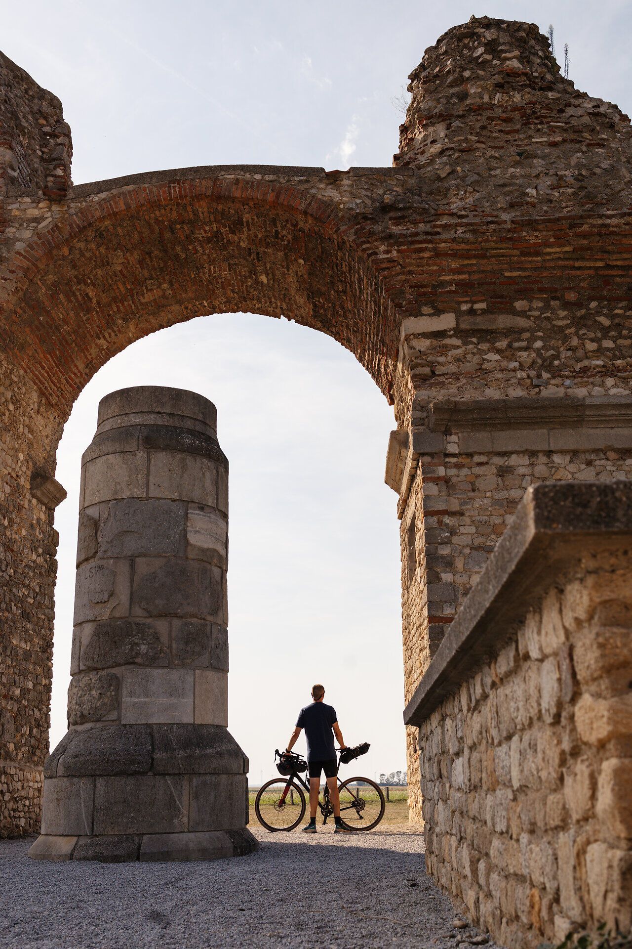 A cyclist enjoys the majestic backdrop of the Heidentor while the warm rays of the sun caress the ancient stones. The gentle breeze and the picturesque landscape invite you to experience the beauty of nature to the full.