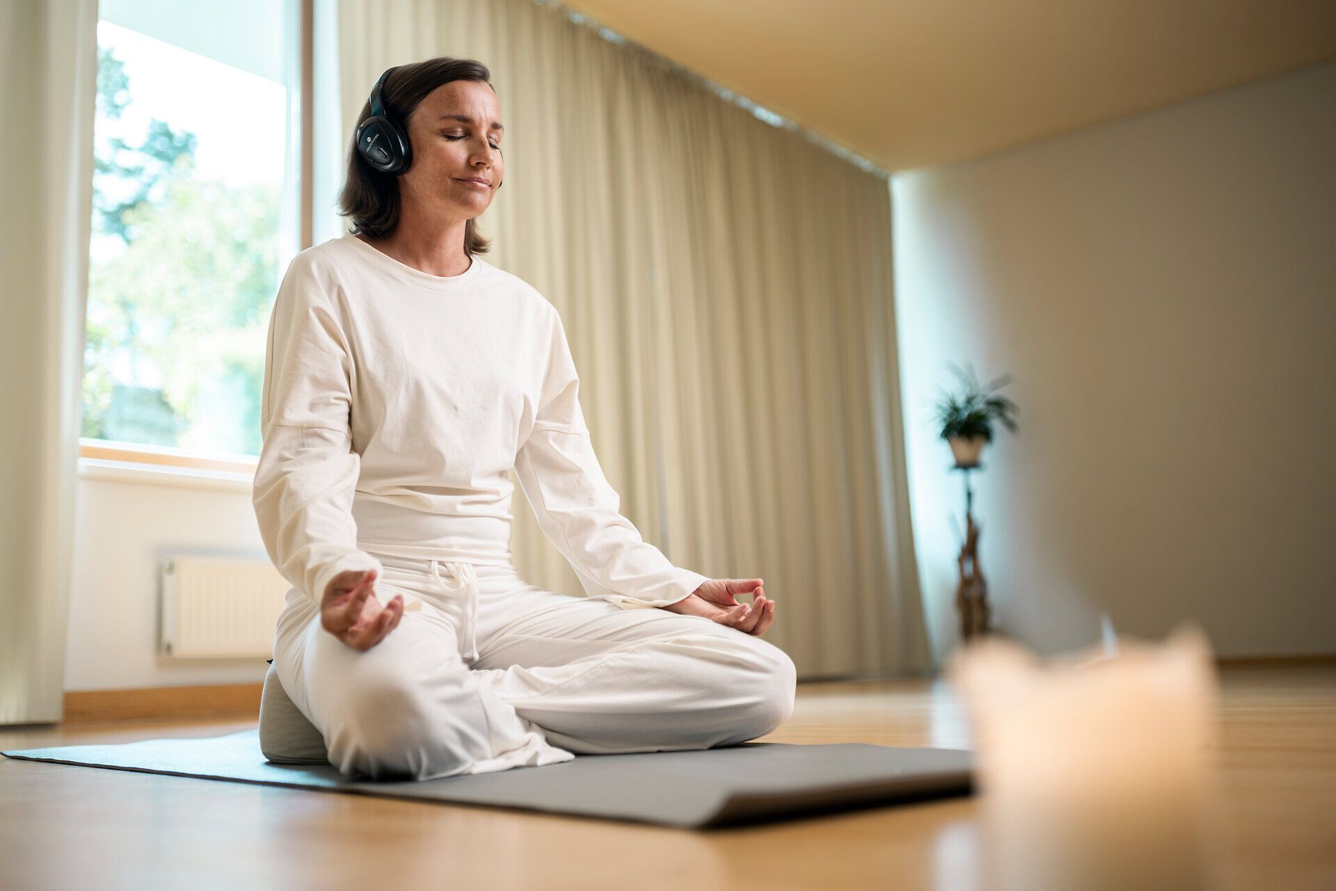A woman is meditating with headphones on at the Klosterberg Health Hotel in the Waldviertel region.