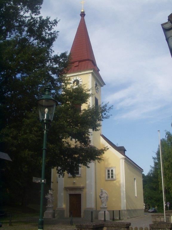Exterior view of Sulz parish church with tower and clock.