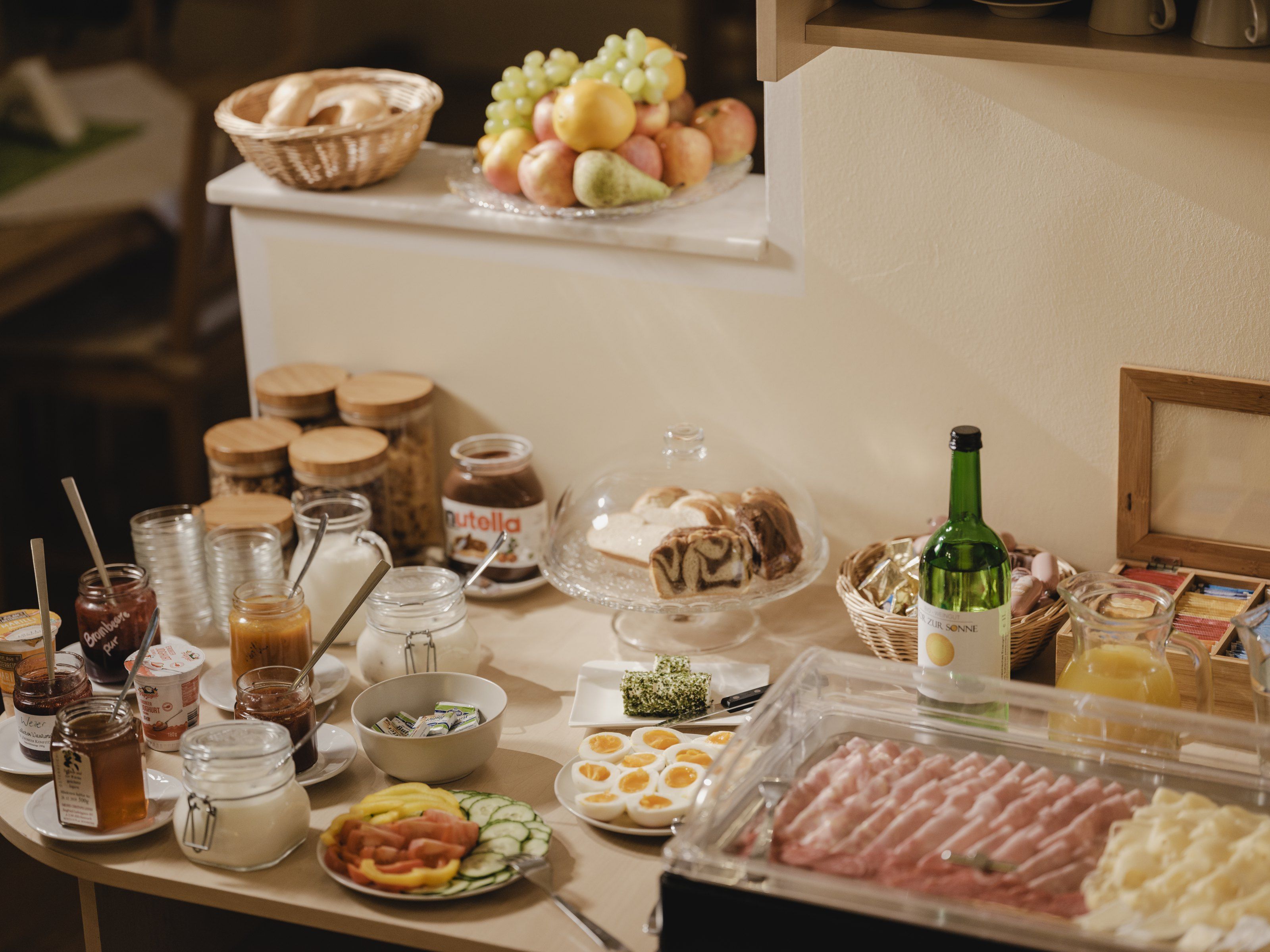 Breakfast buffet with bread, cold cuts, fruit and drinks.