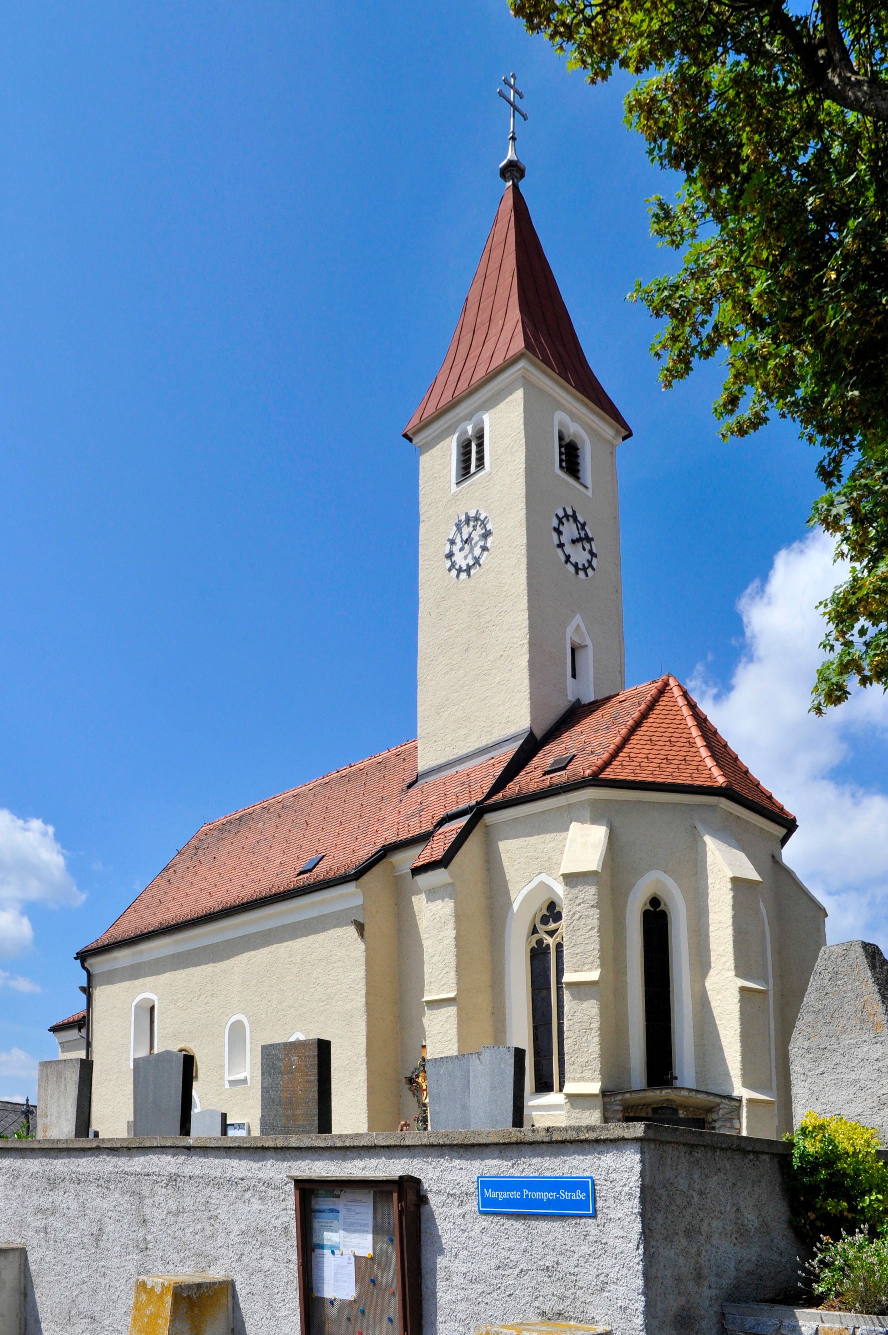 Allentsgschwendt parish church with tower and clock against a blue sky.