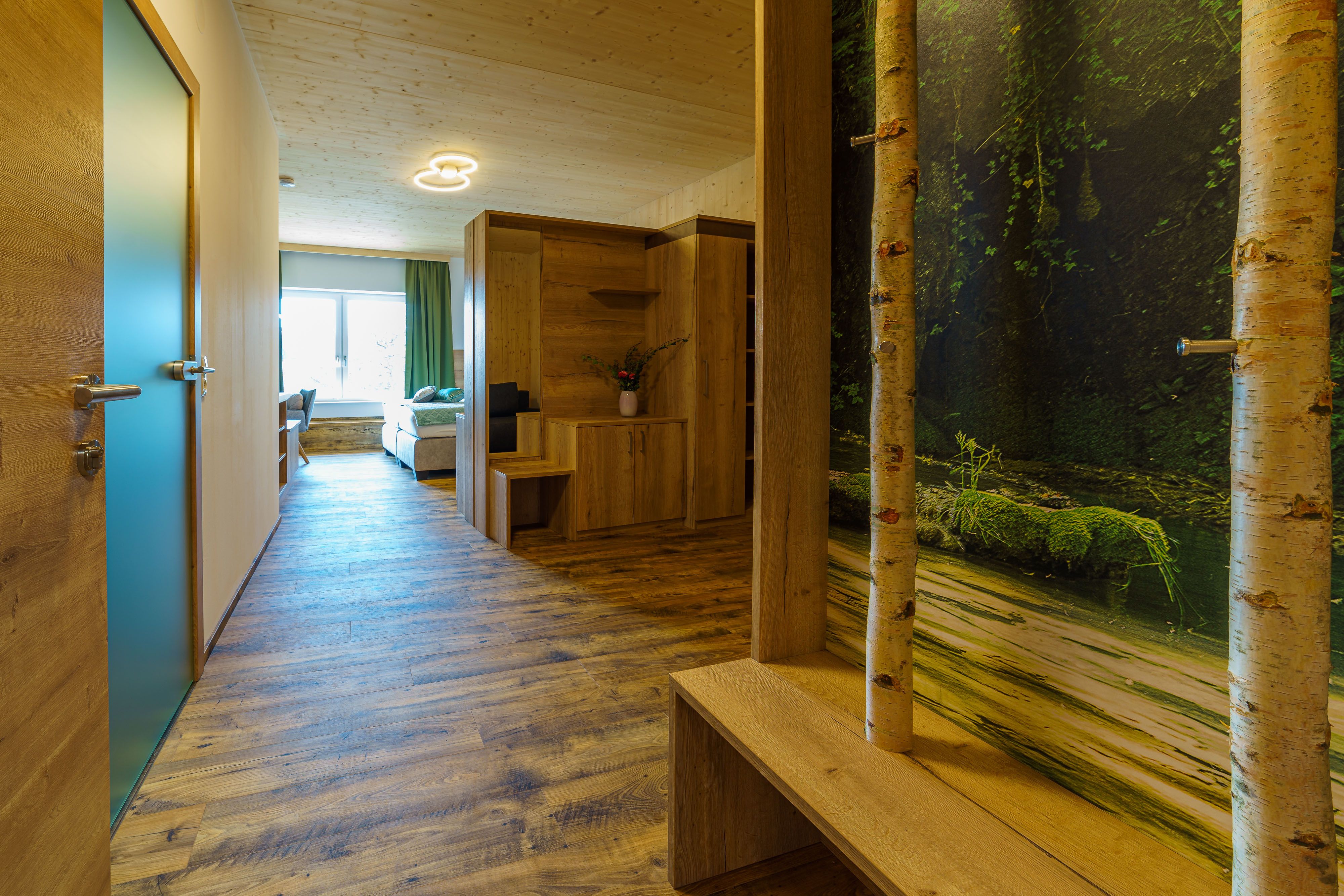 Interior view of a modern apartment with wooden floor, wooden furniture and a large window.
