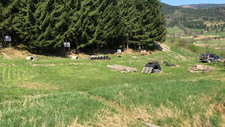 3D archery course with targets and forest in the background.