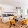 Modern kitchen with dining table and yellow chairs in a vacation apartment.