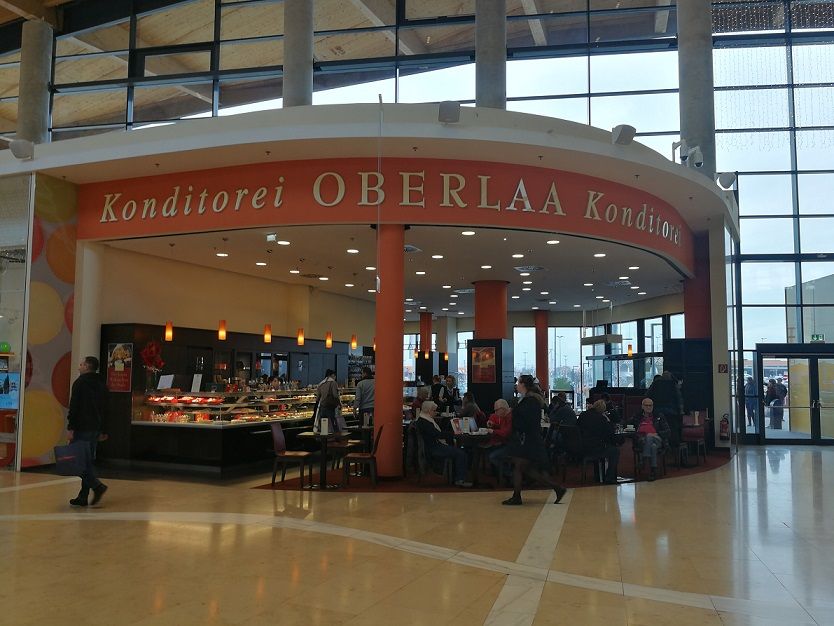 Interior view of Konditorei Oberlaa with guests and counter.