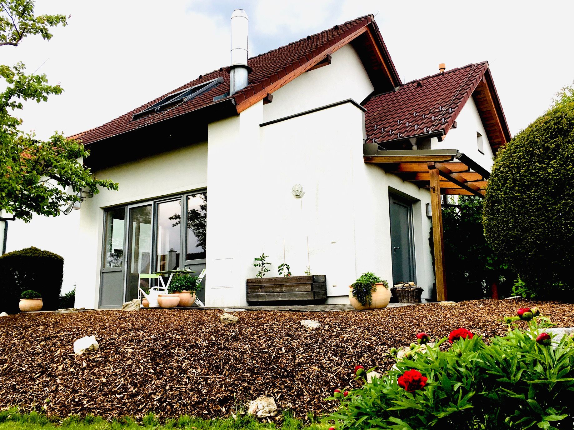 Exterior view of a modern detached house with garden and terrace.