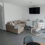 Wohnzimmer mit beiger Couch und weißen Wänden