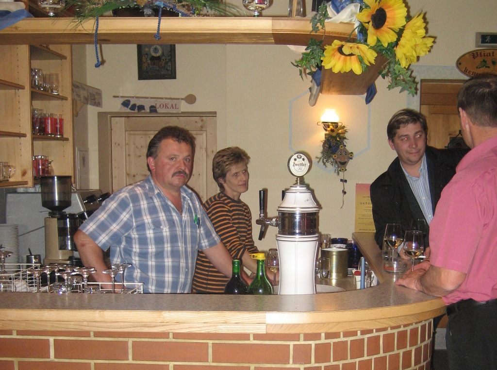 Interior view of a wine tavern with people at the bar.