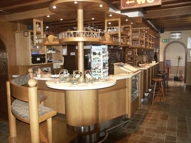 Interior view of a cozy bar with wooden furniture and counter.