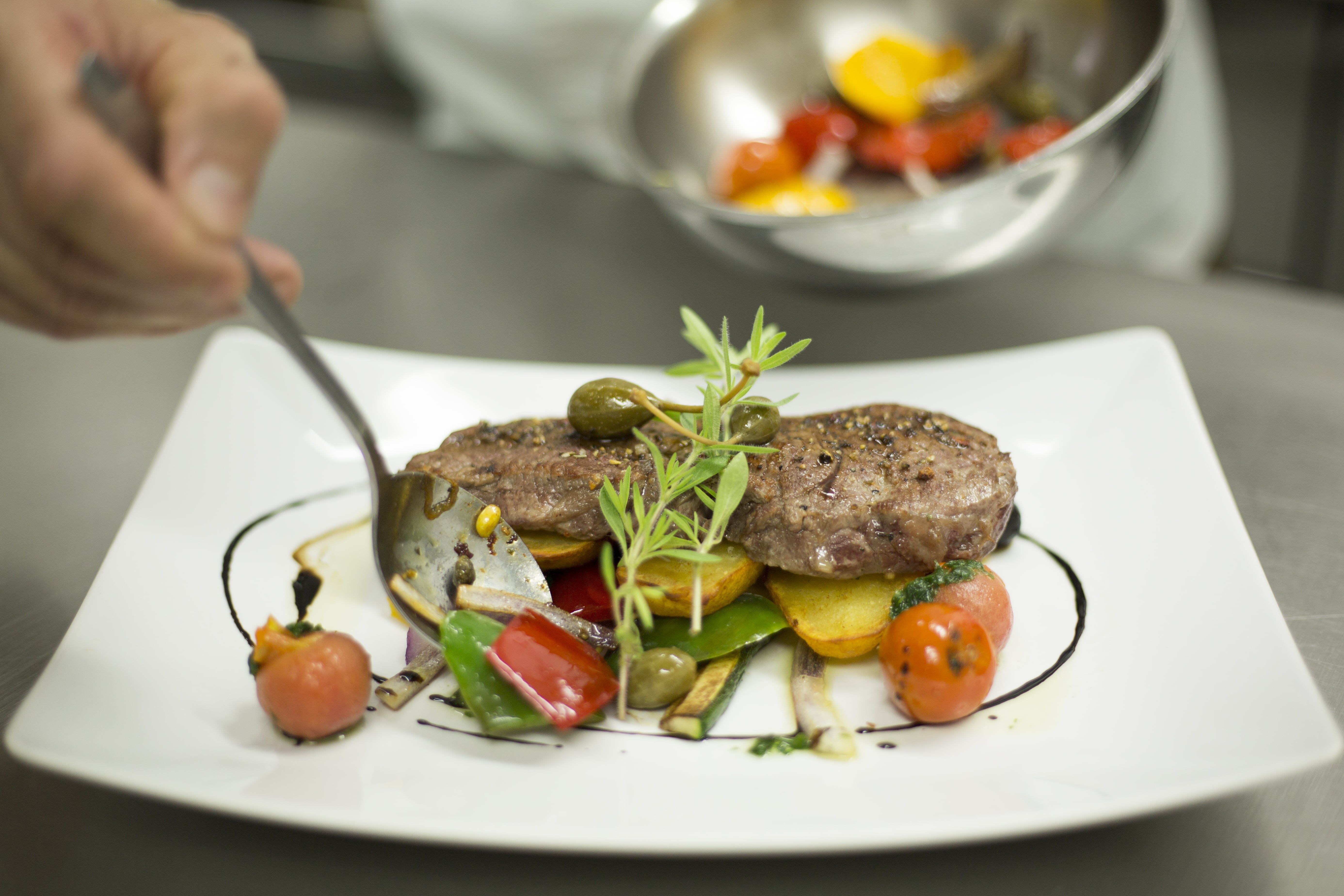 A plate of artfully arranged meat, vegetables and herbs.