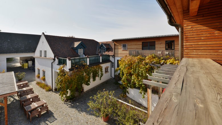Inner courtyard of a winery with wooden buildings and vines.
