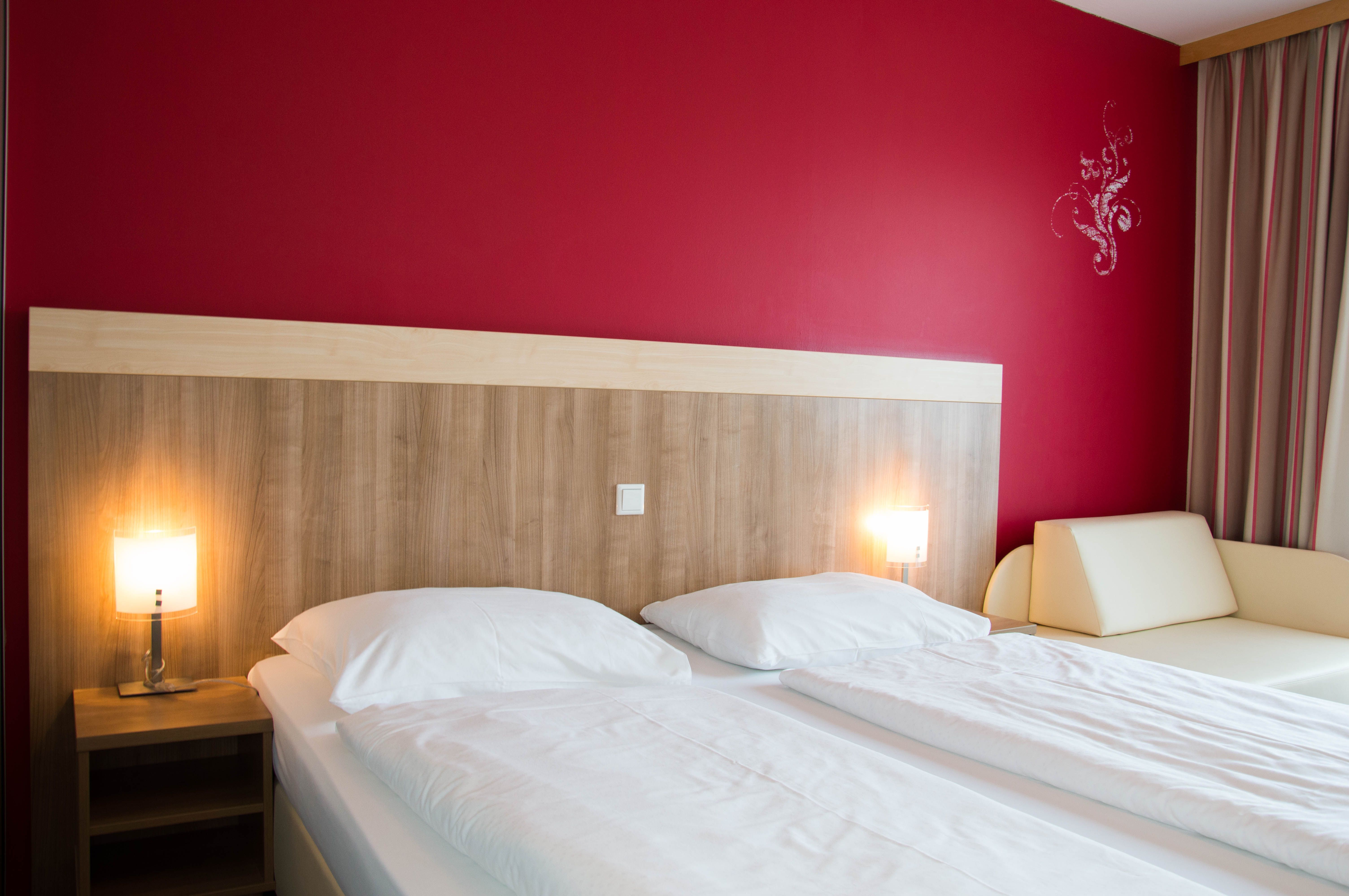 Bedroom with double bed and red wall 