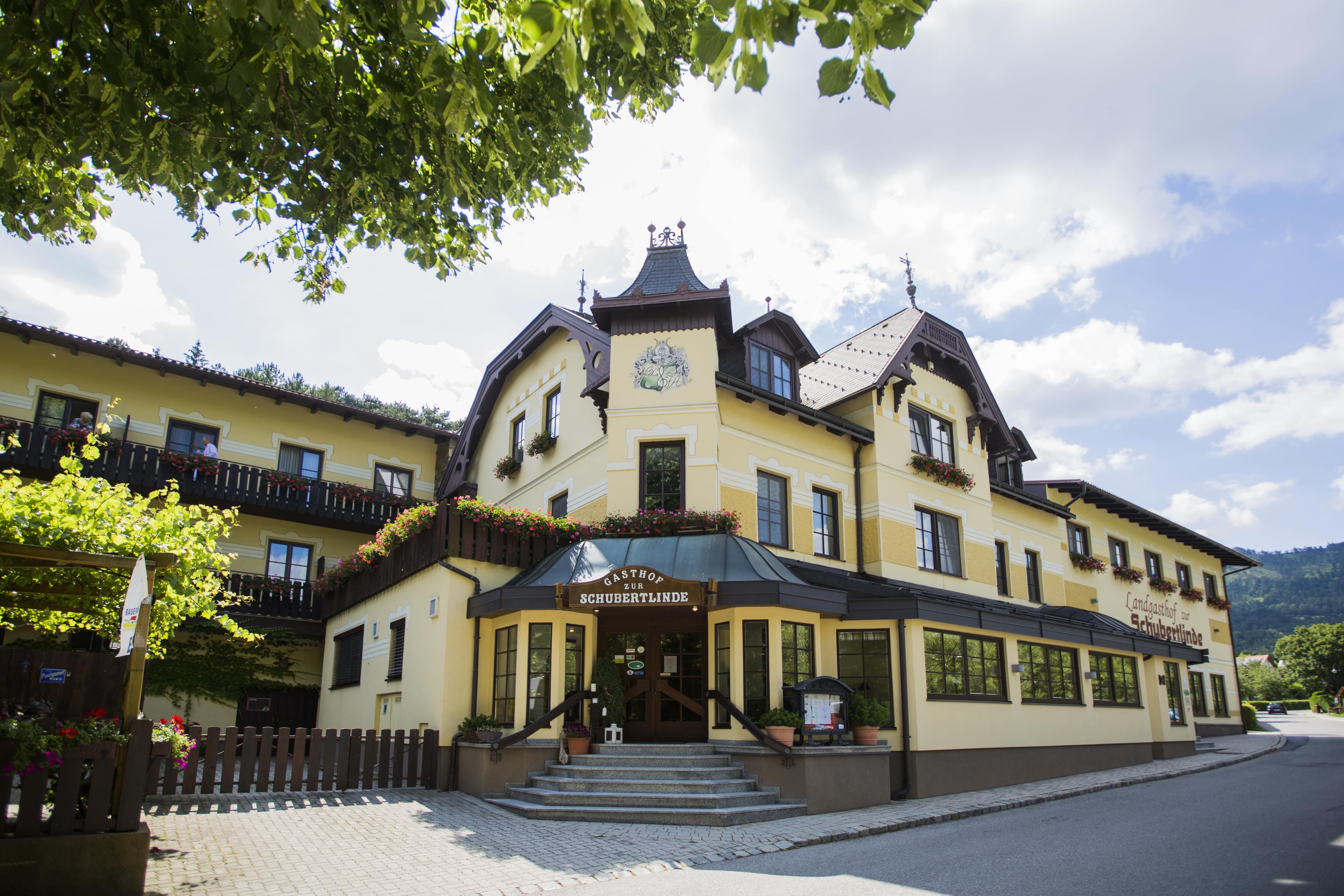 Yellow inn with flowers and blue sky.